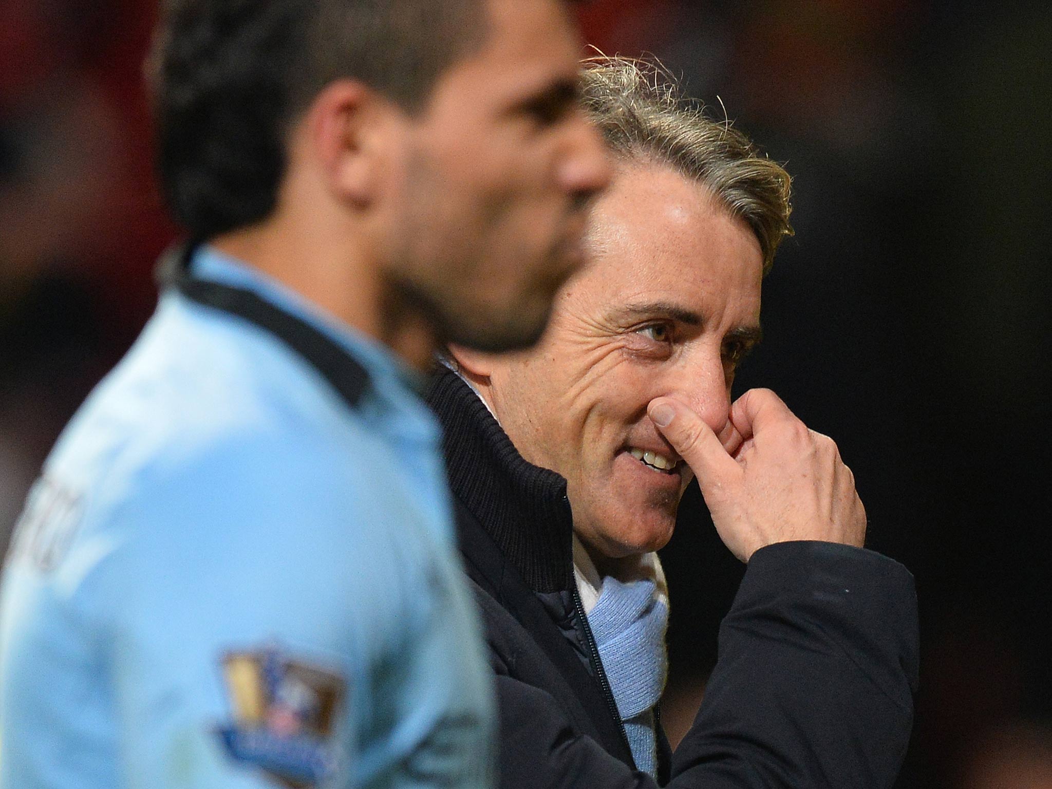 Roberto Mancini leaves Old Trafford with a smile on his face after victory over United