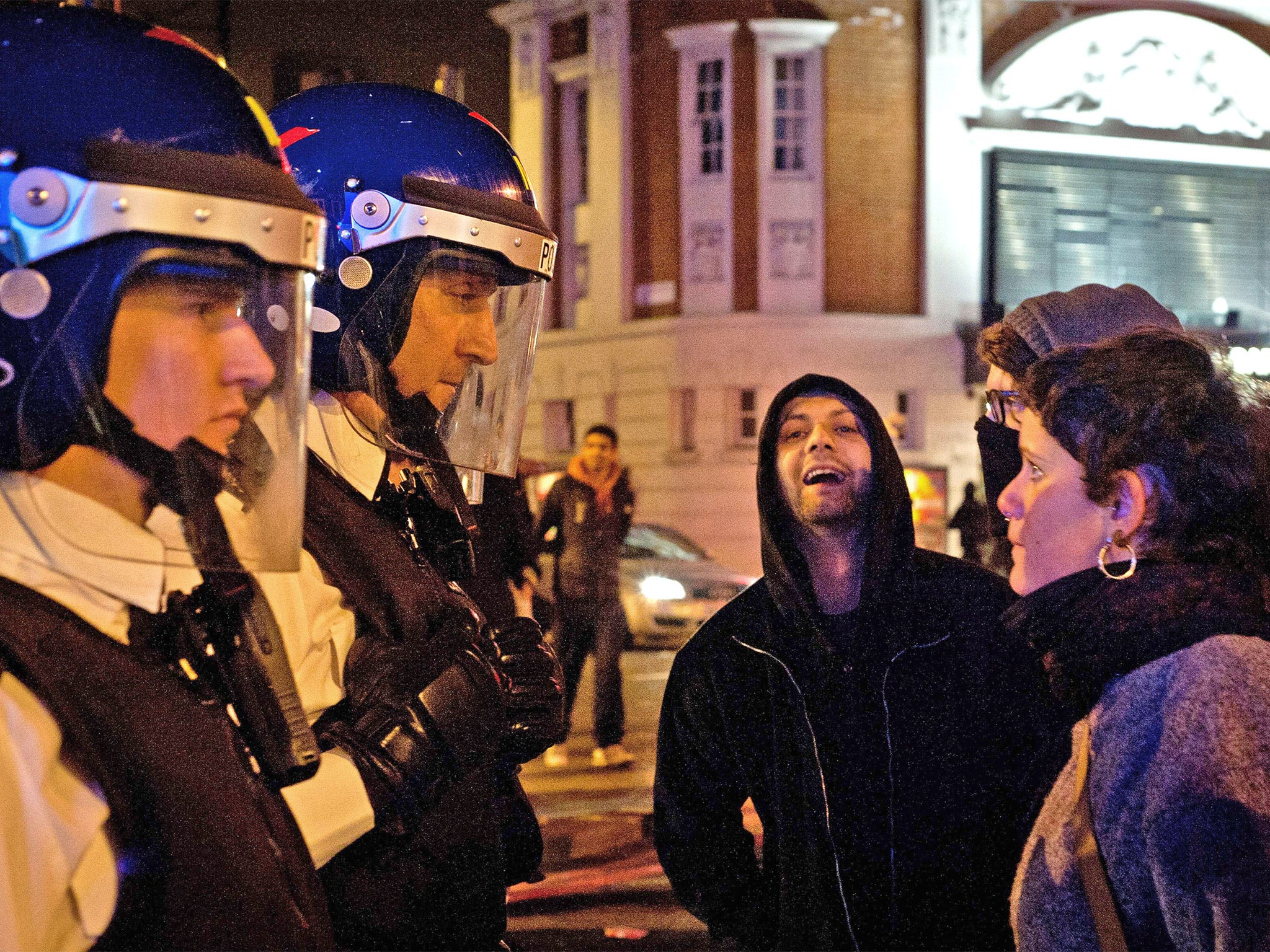 Police speak to protesters during Monday night's unrest in Brixton