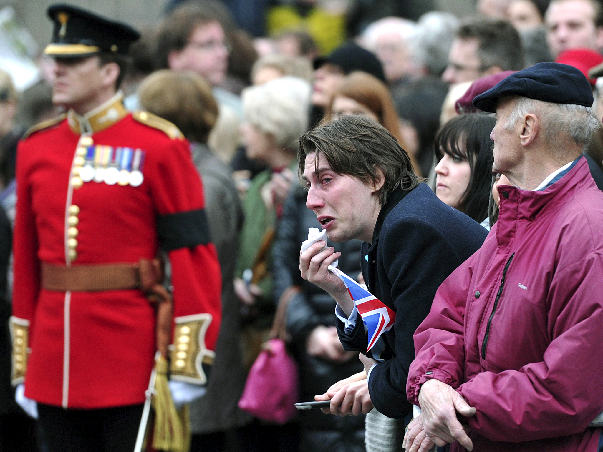 A member of public reacts as the coffin containing the body of the former British Prime Minister Margaret Thatcher passes by during the ceremonial funeral in London