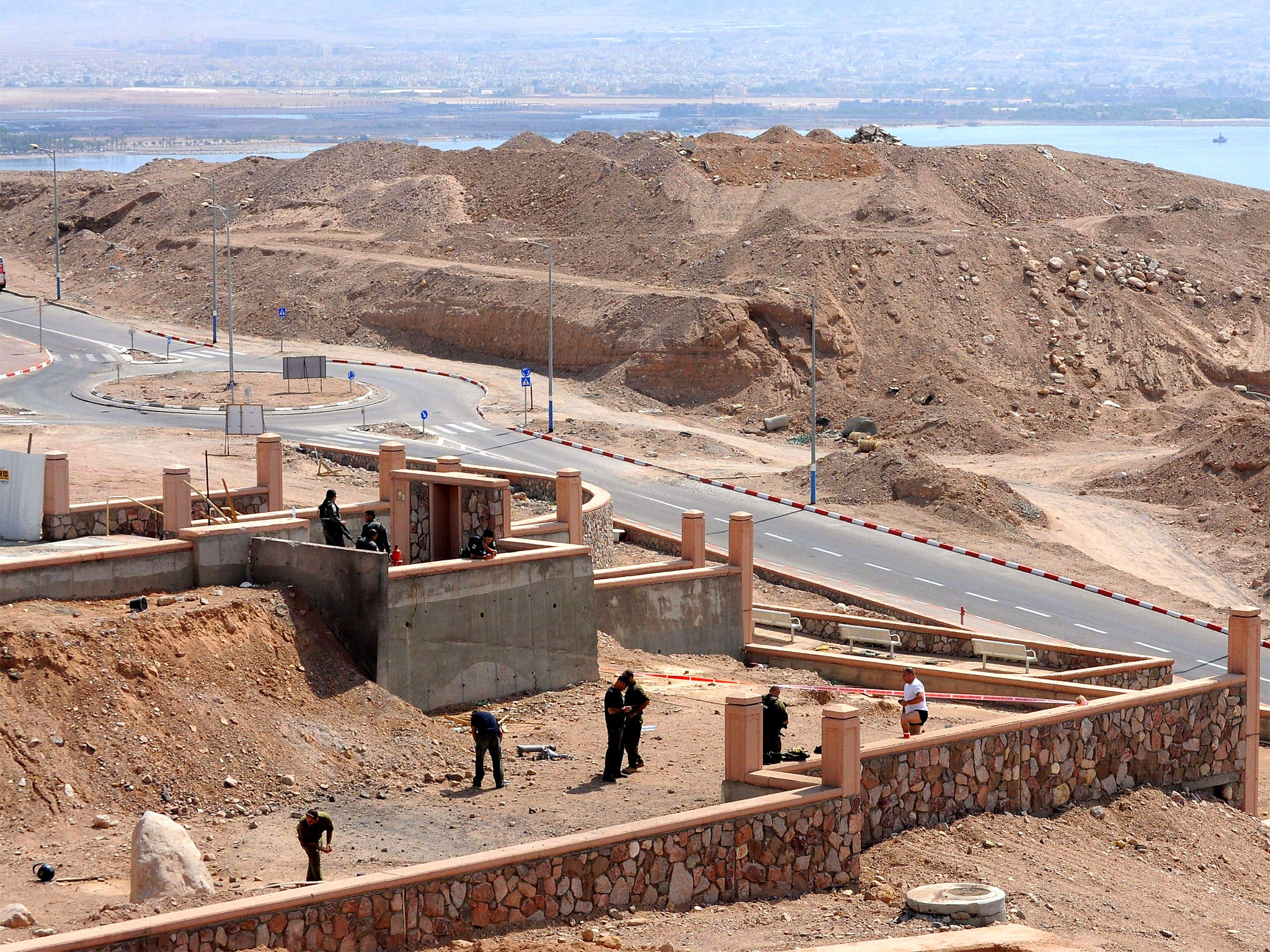 An Israeli policemen inspect the site of a rocket explosion in the Israeli Red Sea resort of Eilat