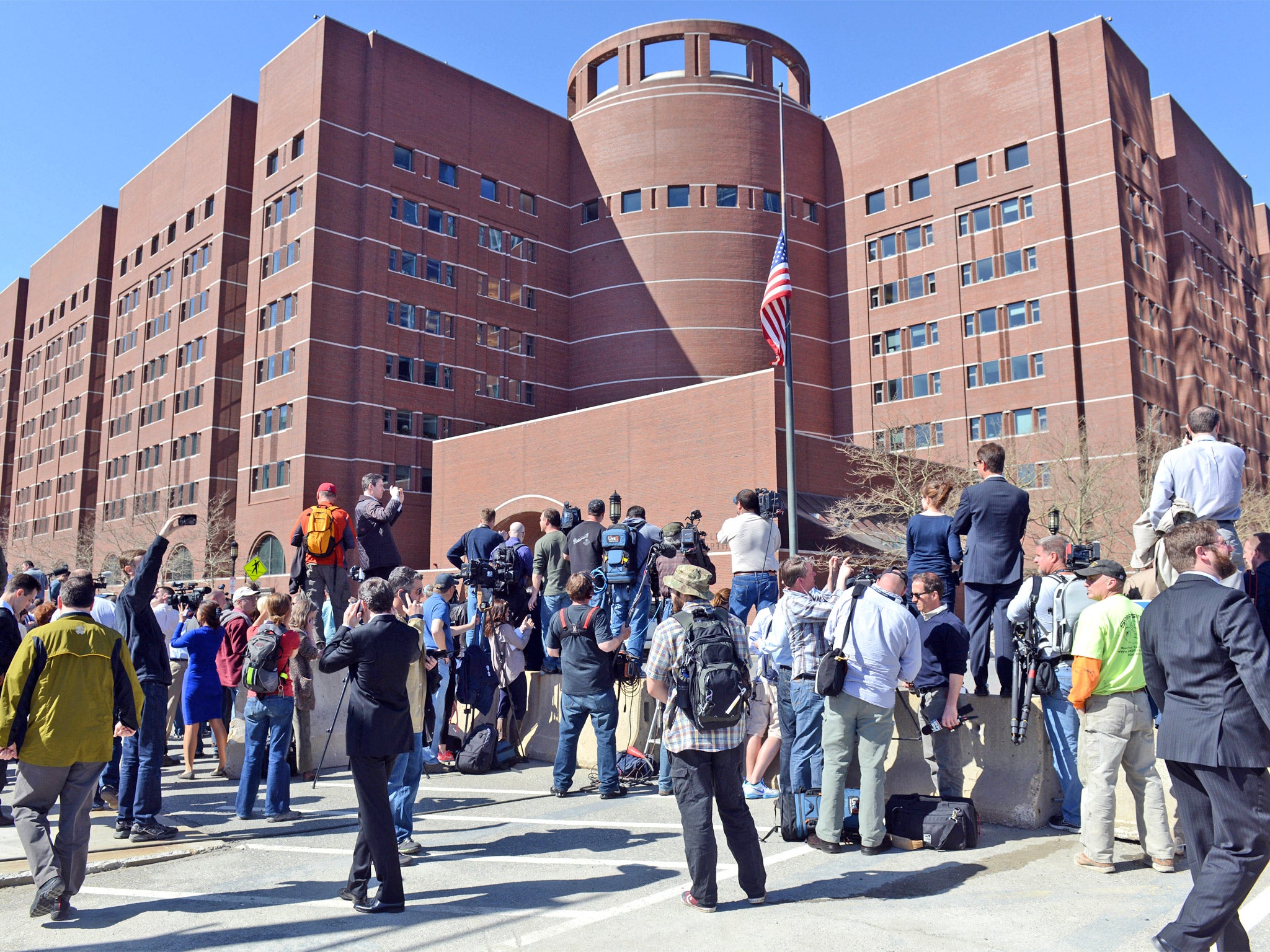 People and media congregate outside the John Joseph Moakley Courthouse amid speculation that a suspect is in custody