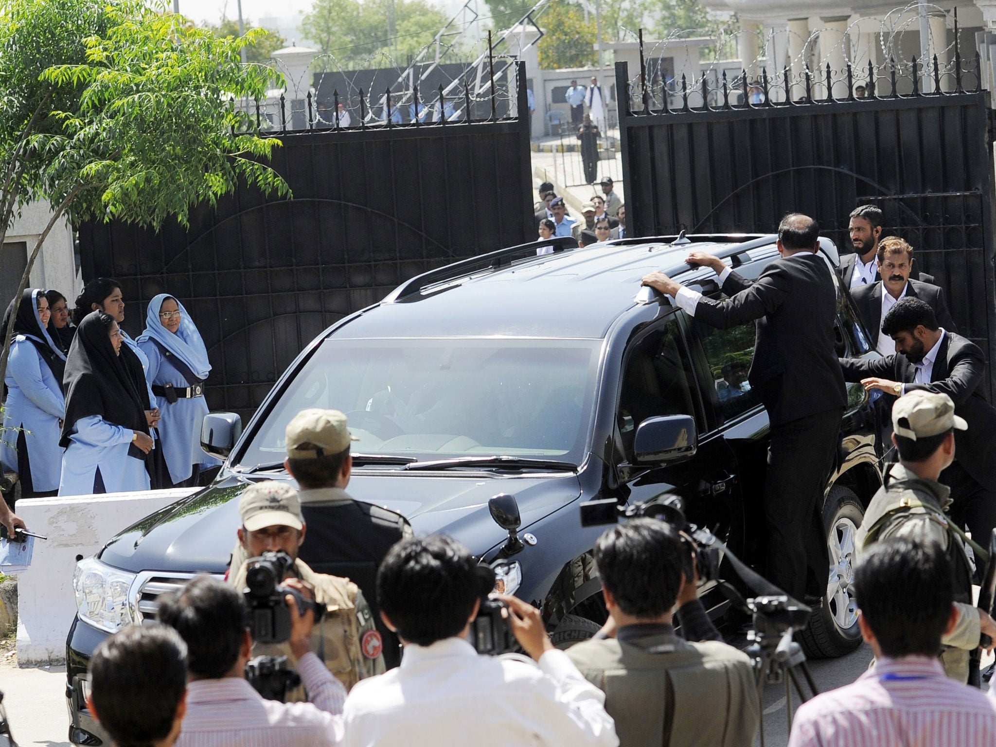 Pakistani special security commandos escort a vehicle carrying former Pakistani president Pervez Musharraf as he leaves the court premises