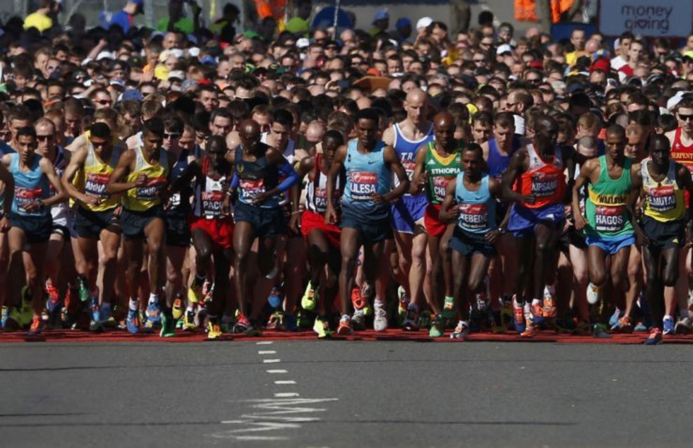 Competitors cross the start line at the beginning of the London Marathon in Greenwich