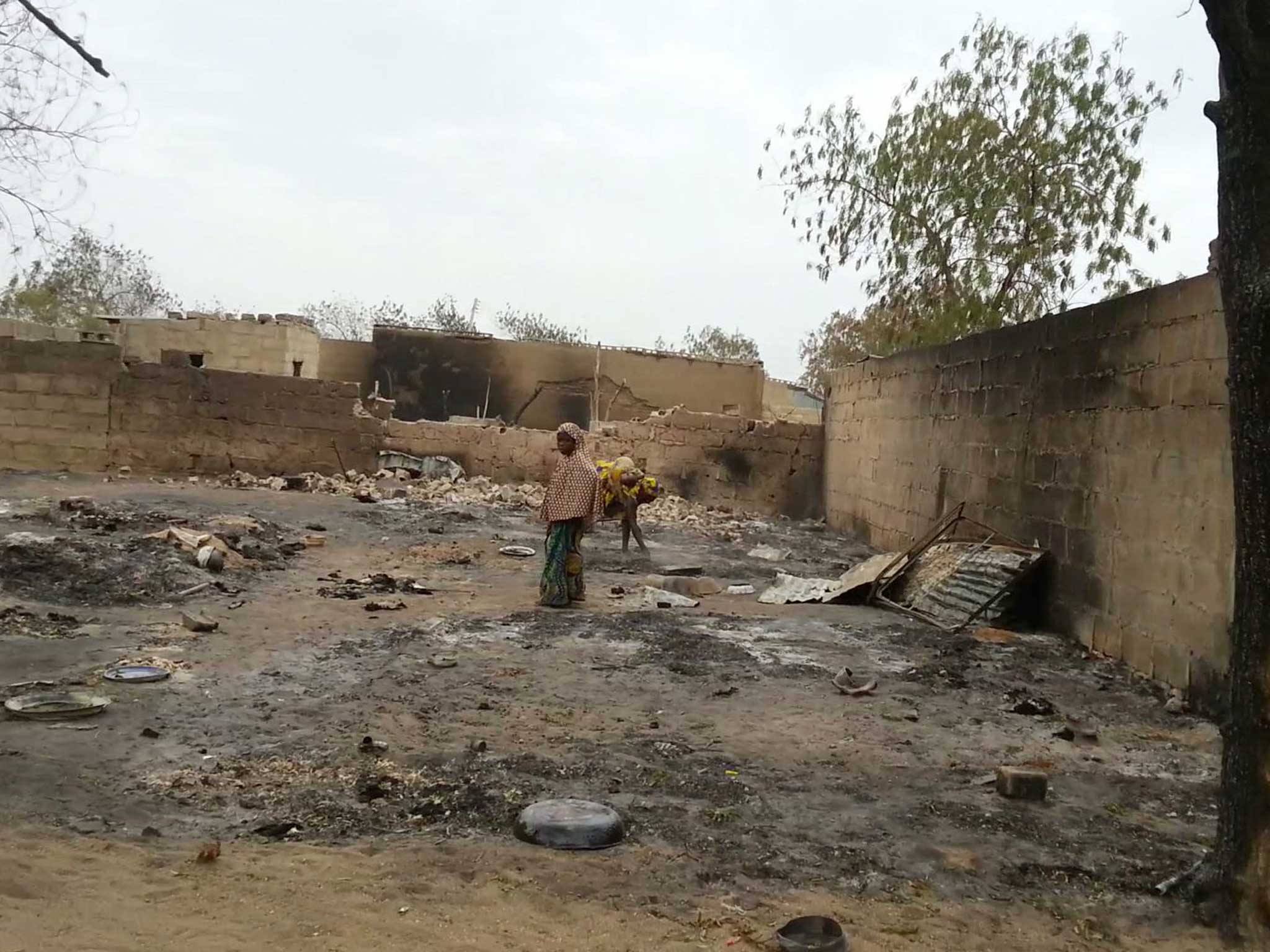 A young girl stands amid the burned ruins of Baga, Nigeria