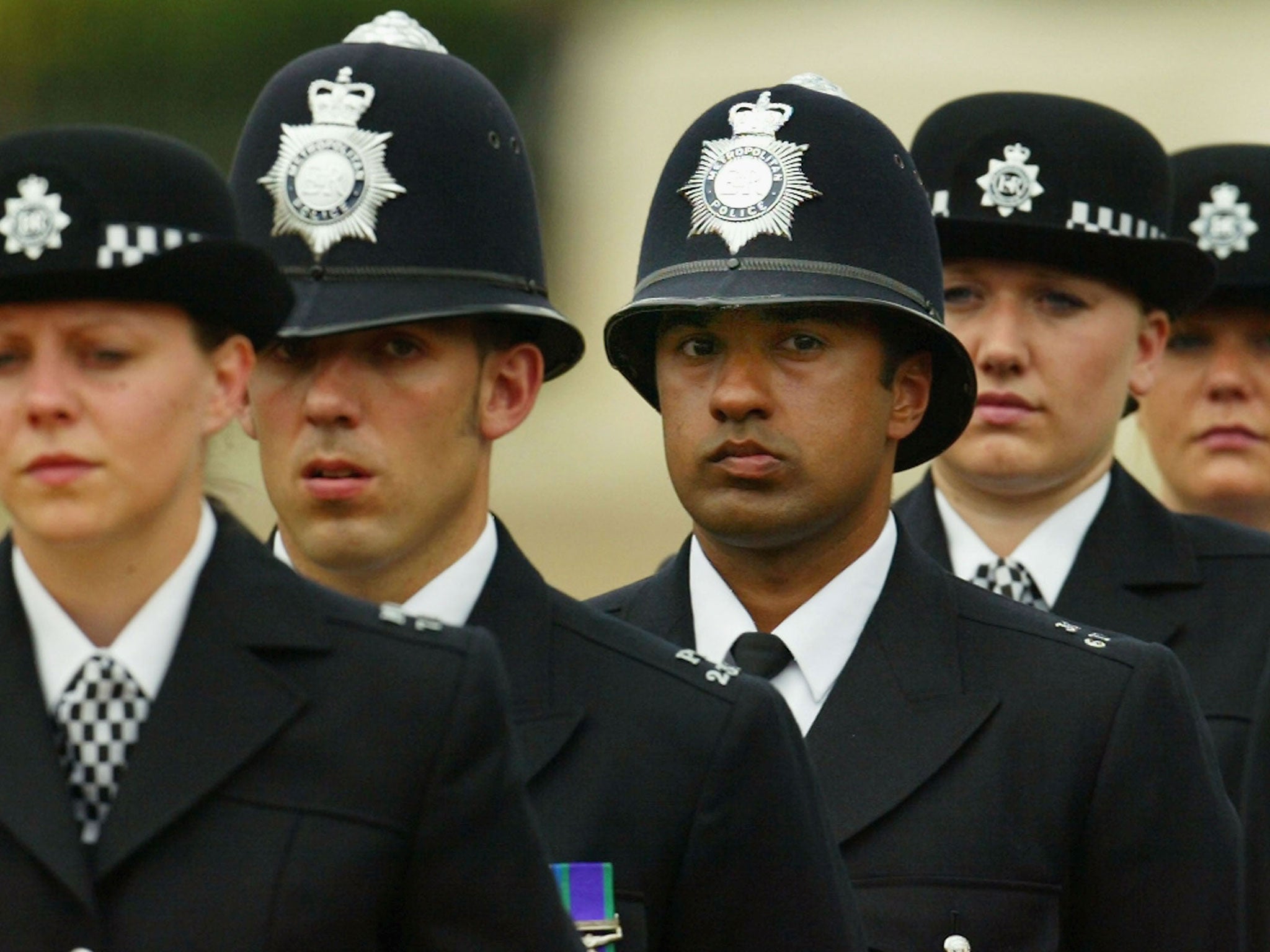 A black British police officer stands to attention during the Metropoitan Police Service's 175th Anniversary service on June 4, 2004 in London, England. The service was attended by various sections of the modern day police family.