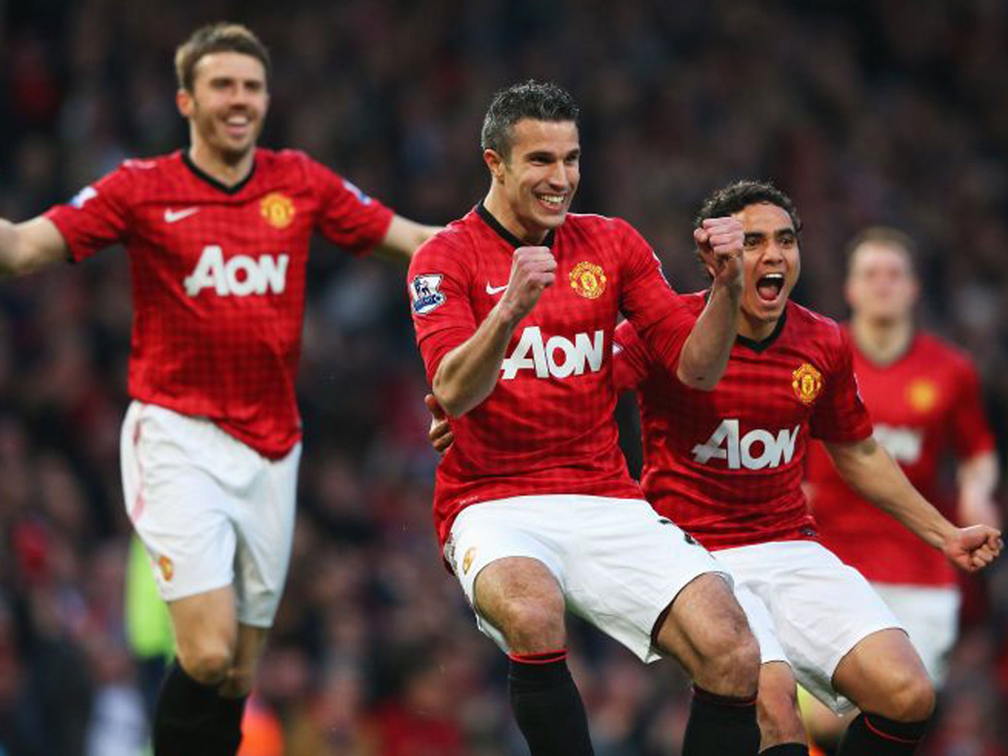 Robin van Persie of Manchester United celebrates scoring the opening goal with Michael Carrick and Rafael during the Barclays Premier League match between Manchester United and Aston Villa