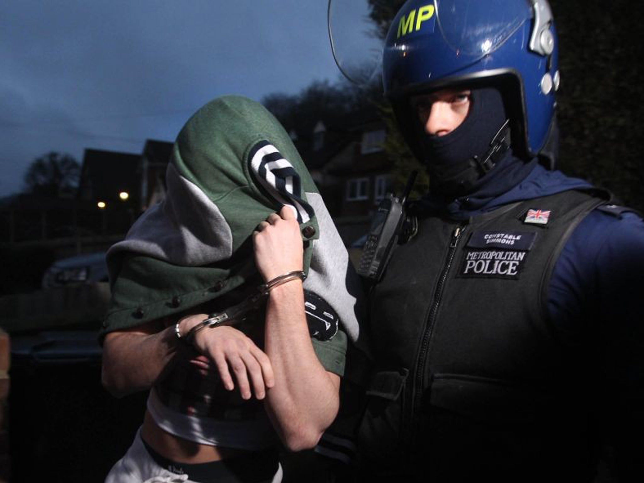 Police make an arrest during an early morning raid in response to recent football violence amongst Millwall fans