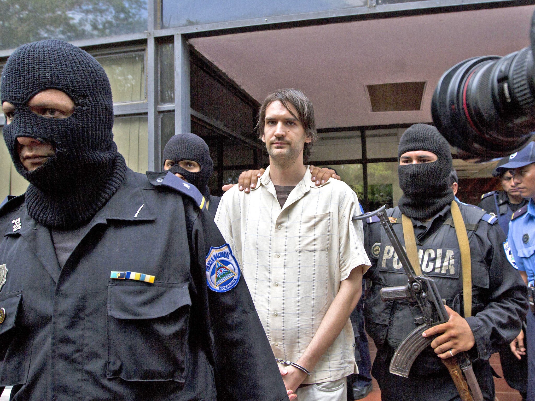 Nicaragua Police agents escort Eric Toth to be presented to the press at a police station in Managua, Nicaragua