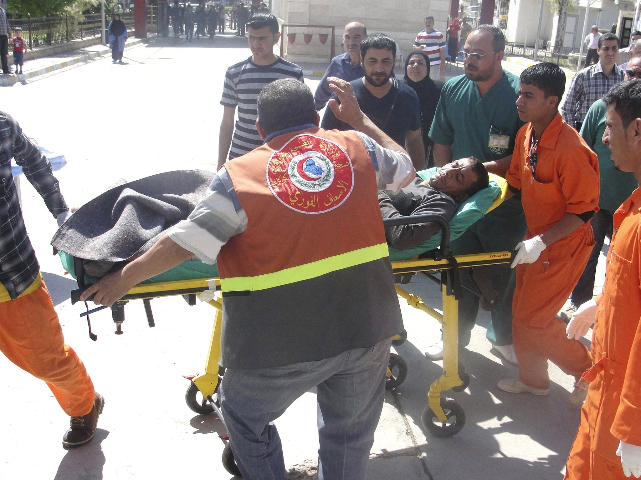 A man is brought to a hospital on a stretcher after after being wounded in a clash between Iraqi forces and Sunni Muslim protesters in Kirku