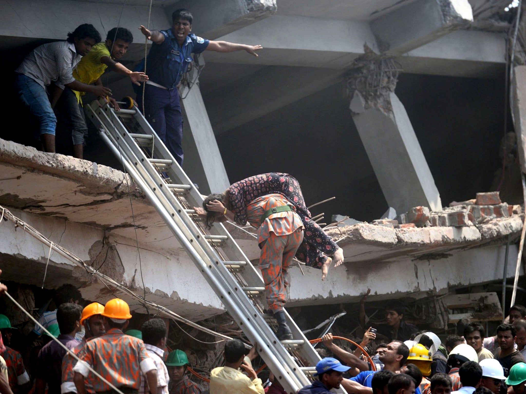 A firefighter carries an injured garment worker after an eight-storey building collapsed in Savar, on the outskirts of Dhaka