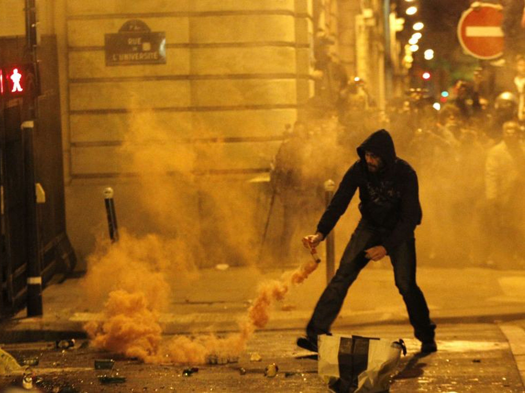 A demonstrator faces riot police