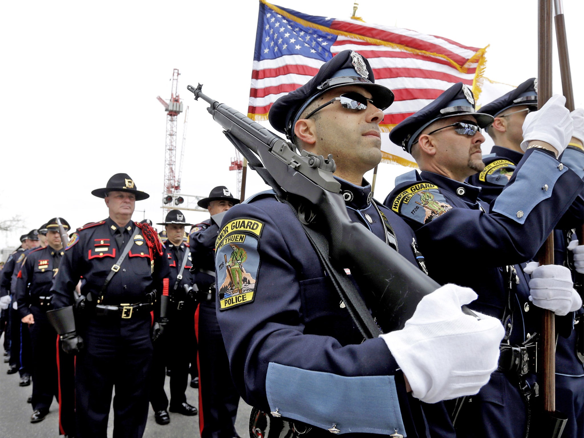 Members of a police honor guard lead a column of law enforcement officials into a memorial service for fallen Massachusetts Institute of Technology police officer Sean Collier