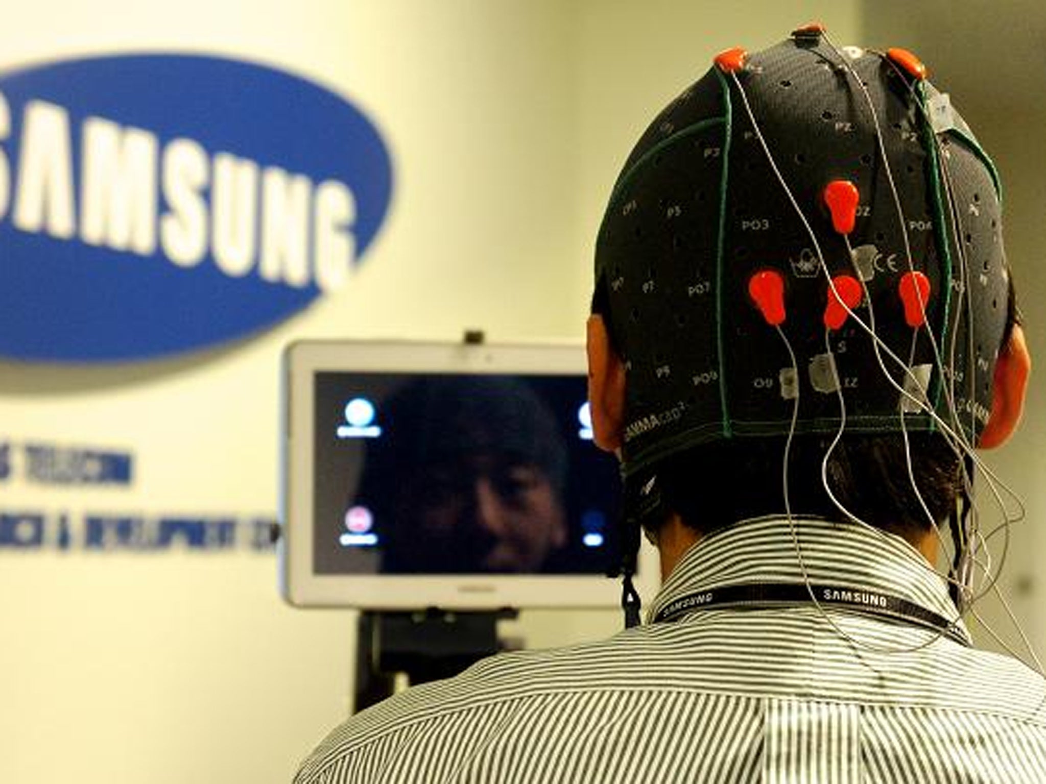 The user wears a cap fitted with EEG electrodes to monitor brain activity