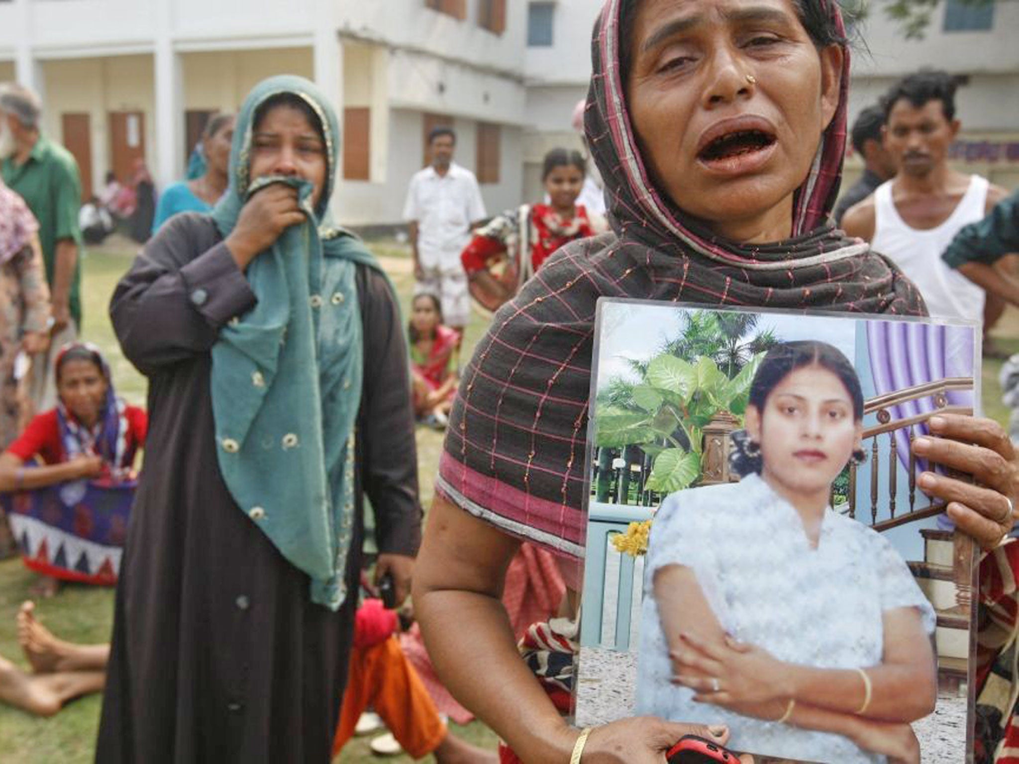 A woman mourns holding the photo of her daughter after the collapse of the eight-storey building Rana Plaza in Bangladesh