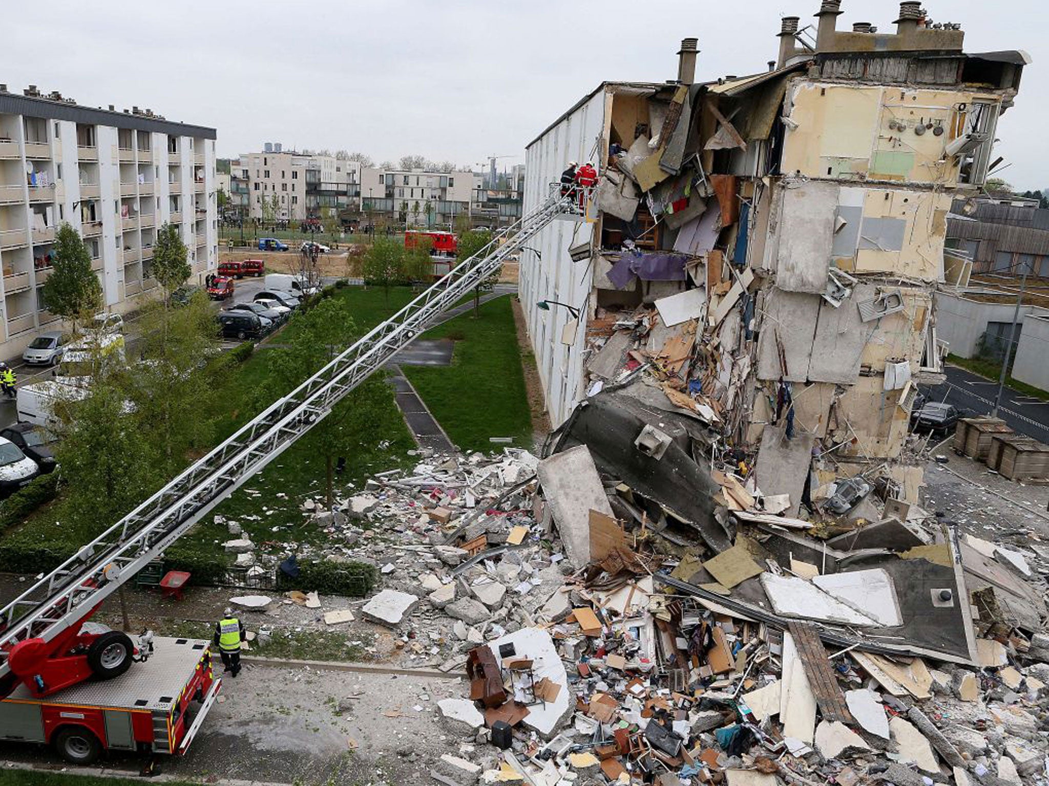 Firemen at work near the collapsed section of an apartment building in Reims, eastern France, after a suspected gas explosion killed at three people and injured nine others