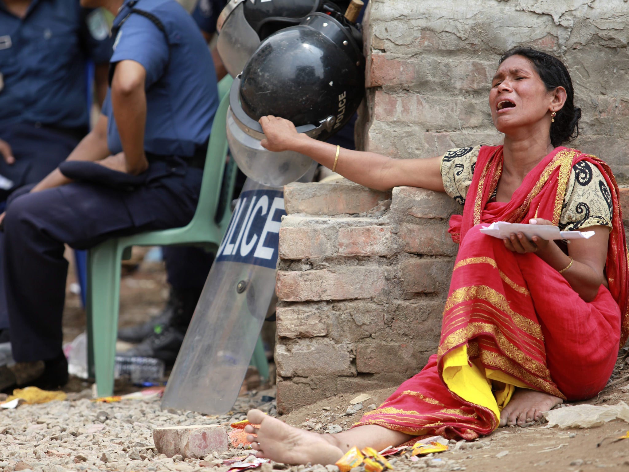 A woman in Dhaka holds a photo of her missing son