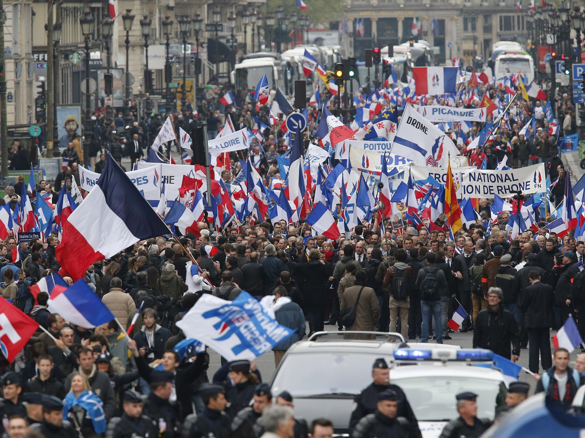 Supporters of France's far-right National Front Marine Le Pen wave flags during the traditional May Day march in Paris