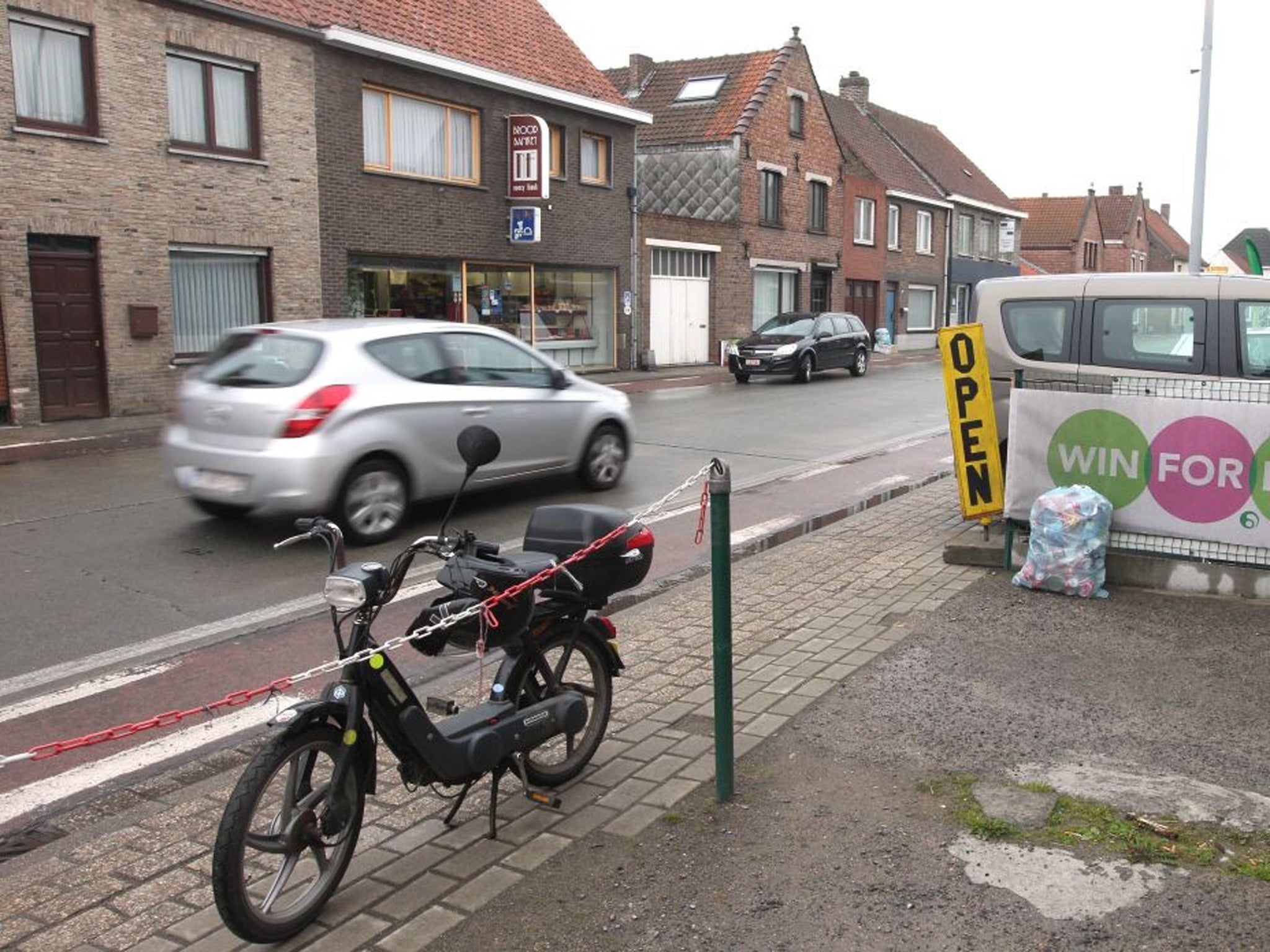 A car passes down the street in Zedelgem where robbers lost their cool and threw a vault containing €1m from their getaway car