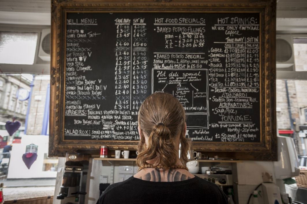 Catherine Henderson in front of the board at Edinburgh vegetarian restaurant Henderson's