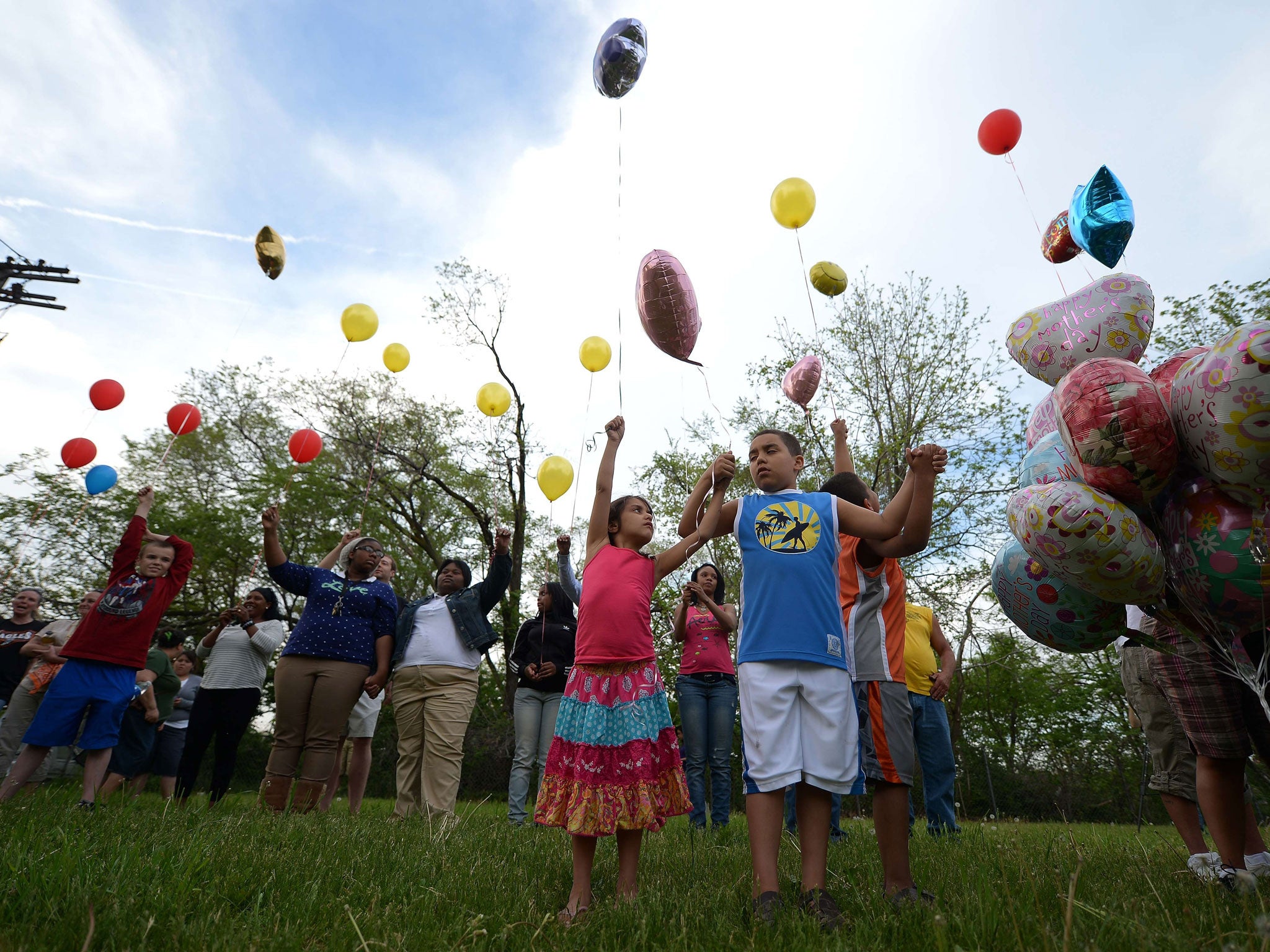 Children release balloons as part of a gathering outside a community meeting at Immanuel Lutheran Church held to talk about the kidnapping of Michelle Knight, Gina DeJesus and Amanda Berry by neighbour resident Ariel Castro