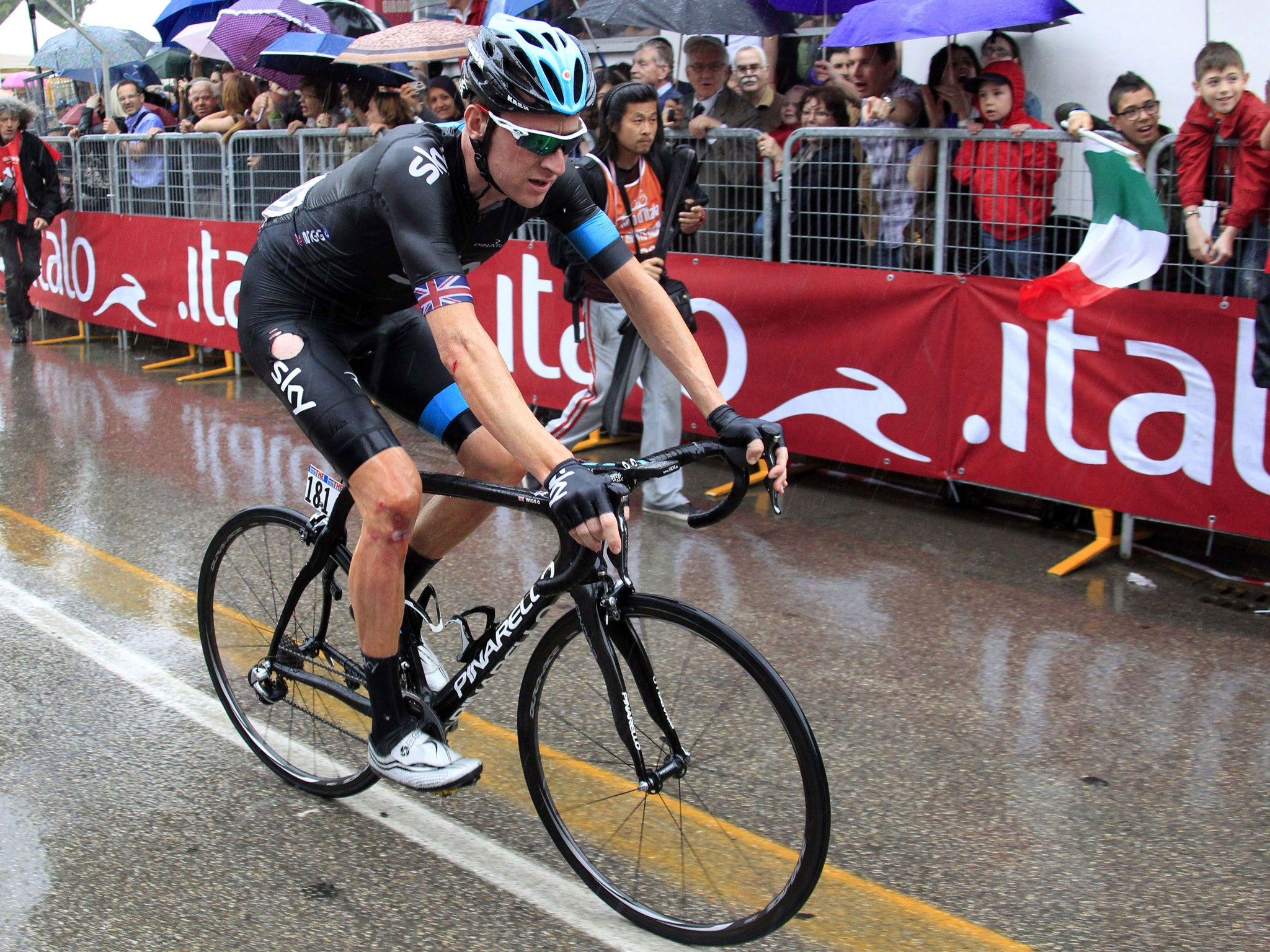 Bradley Wiggins struggles to the finishing line in the rain after crashing during yesterday’s stage