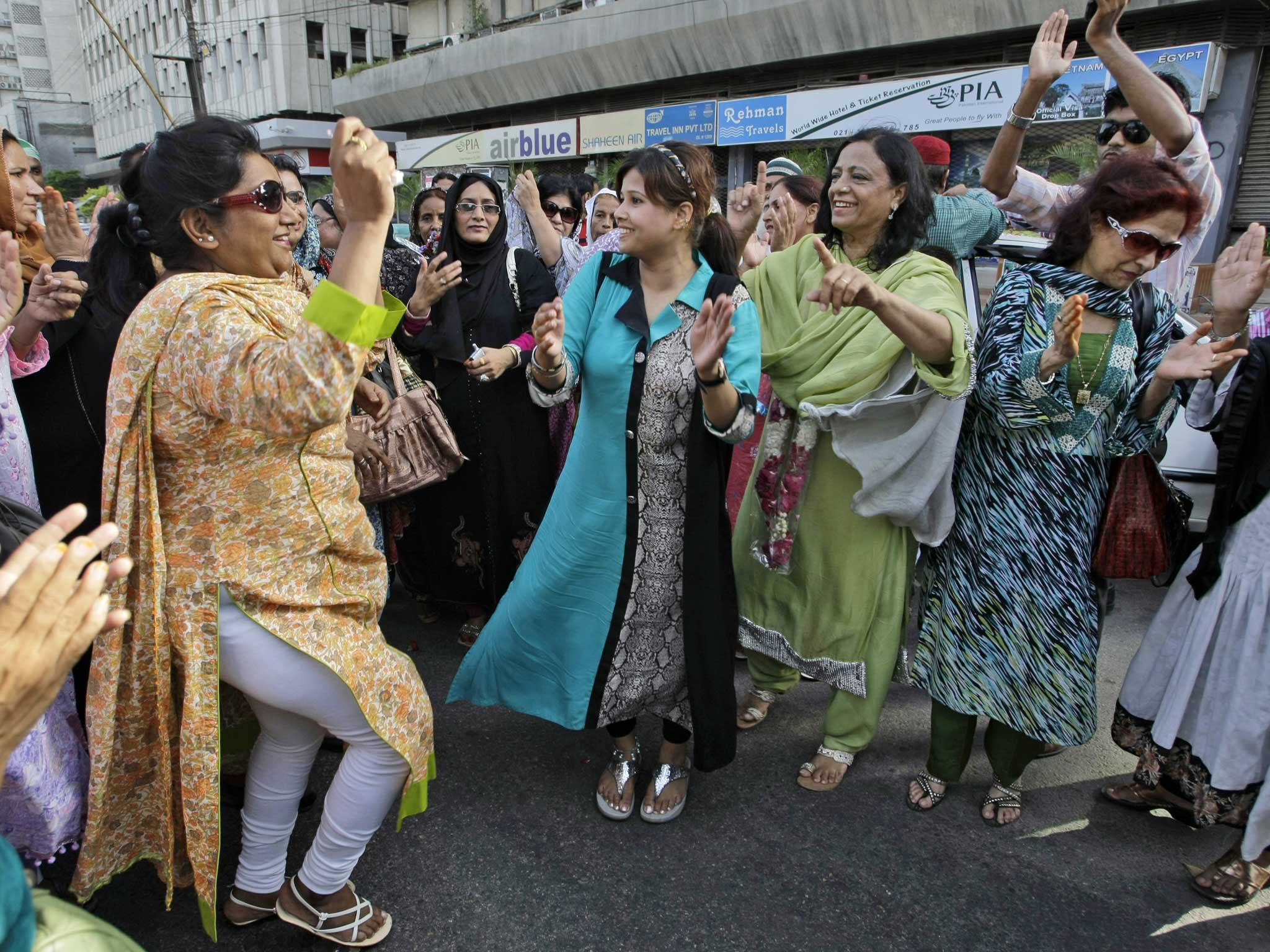 Supporters of Pakistan's former Prime Minister Nawaz Sharif deliver sweets while celebrating his victory