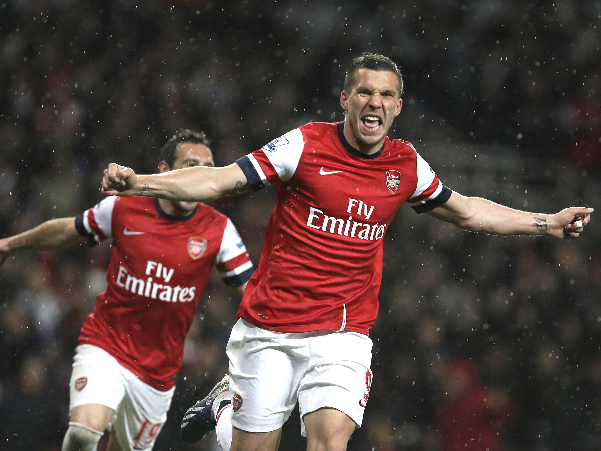 Podolski celebrates his second of the night, Arsenal's third