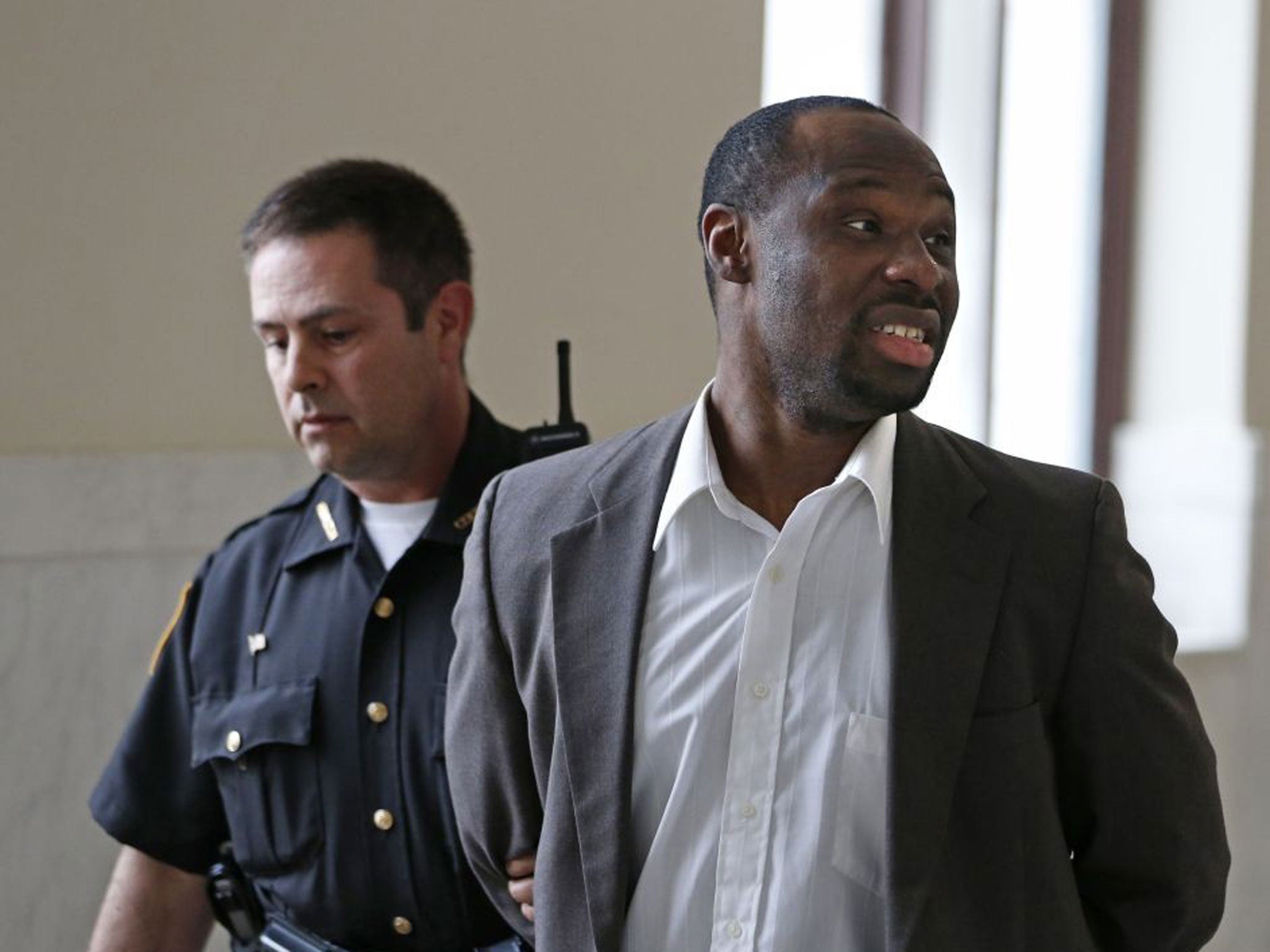 Ricardo Woods being taken from court after he was found guilty in the shooting death of a man who authorities say identified his assailant by blinking his eyes while paralyzed.