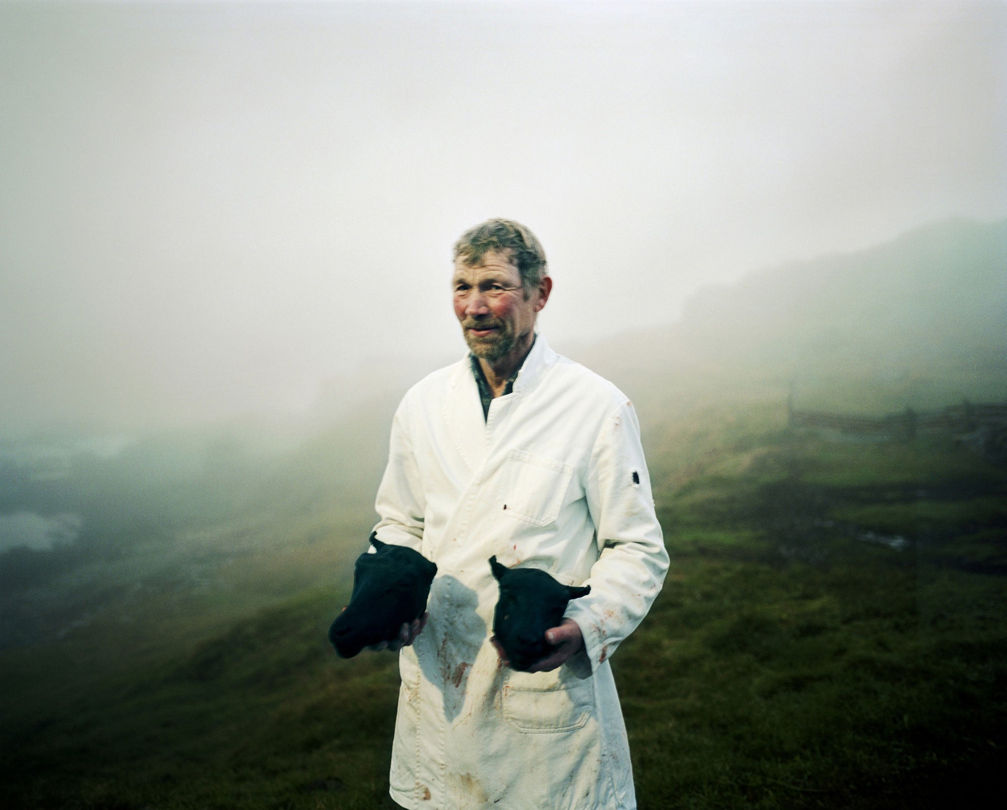 Arnes farmer Ulfar with the heads of two sheep. In October, farmers slaughter a few sheep to have meat for the rest of the year - the heads are singed to remove the wool, then boiled and eaten