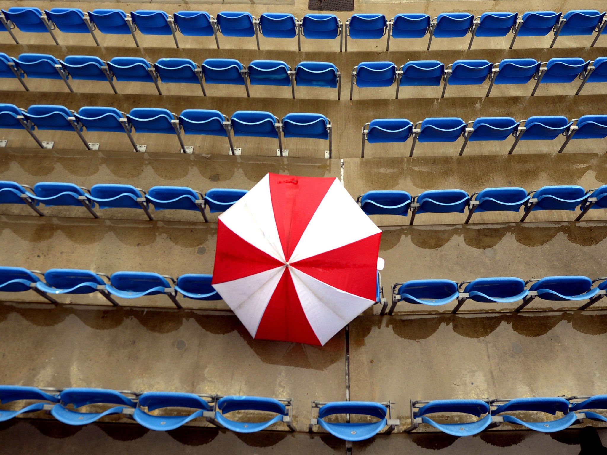 An optimistic fan sports a lone umbrella among Headingley's  empty seats