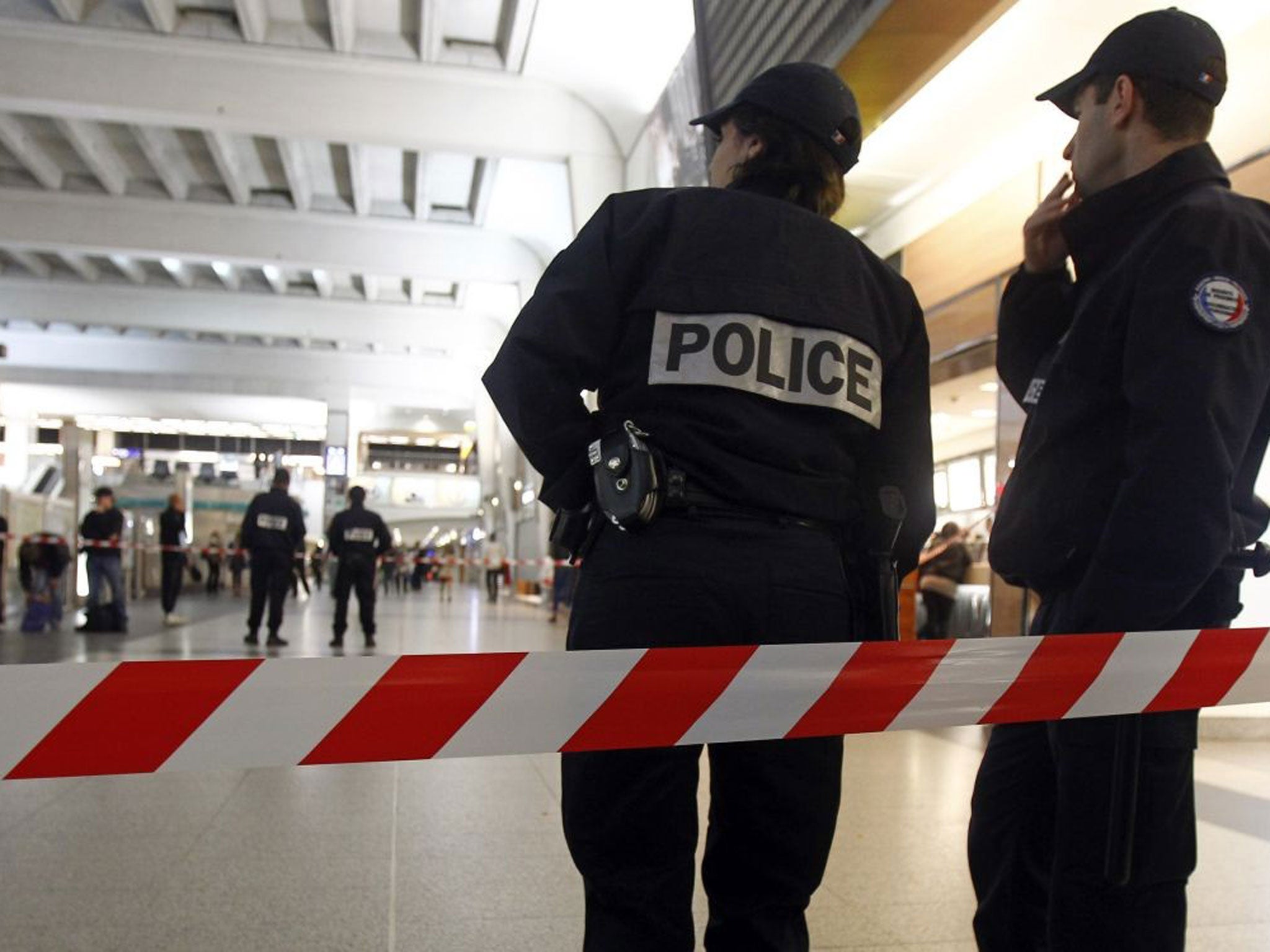 Police officers stand near the cordoned off spot where a French soldier was stabbed in the throat