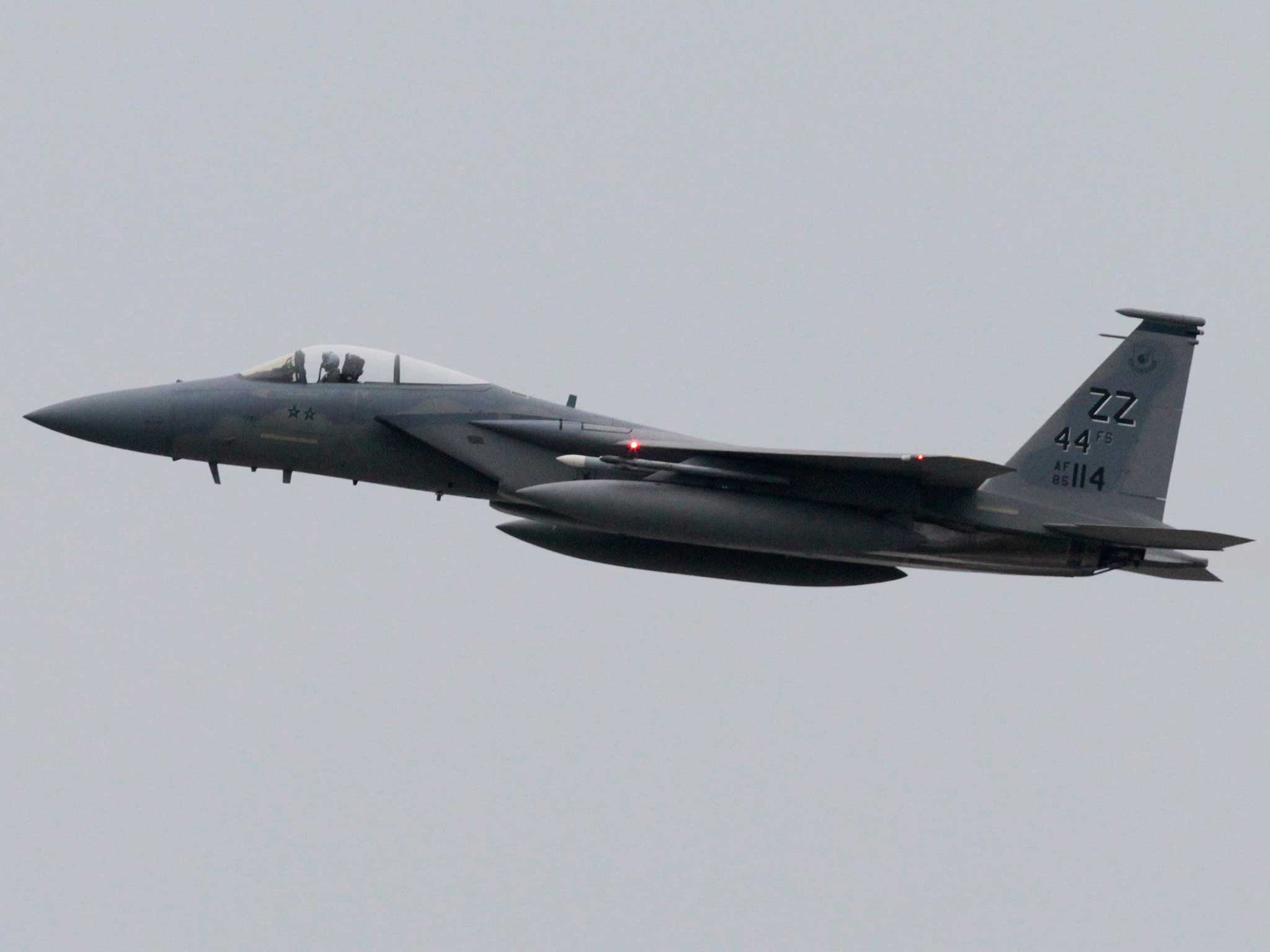 A US Air Force F-15 aircraft flying over the US air force Kadena Air Base in Kadena city, Okinawa