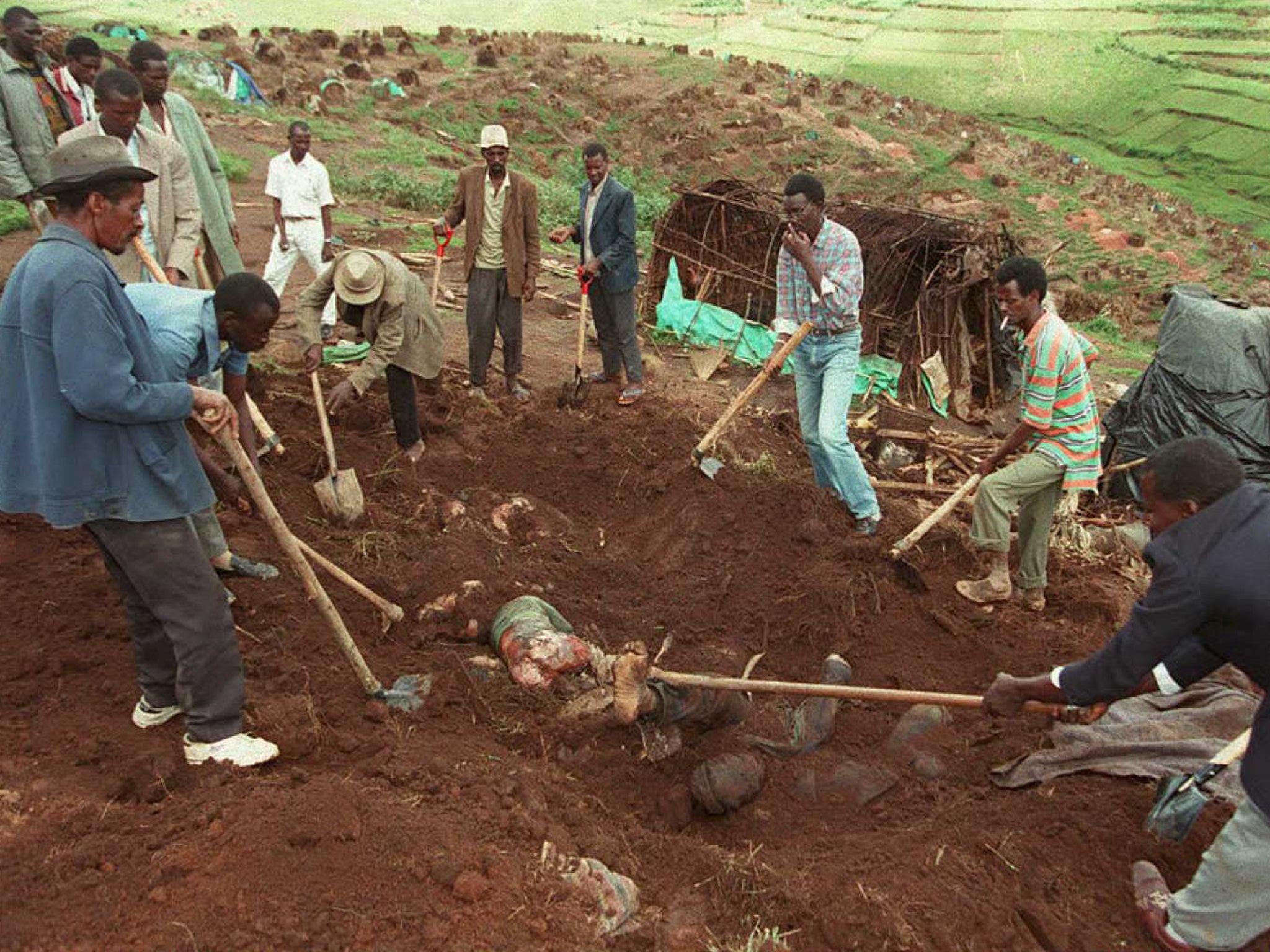 Workers exhume bodies from a mass grave at the Kibeho refugee camp in April 1995 to count the dead following the massacre of Hutu refugees allegedly carried out by the Rwandan army