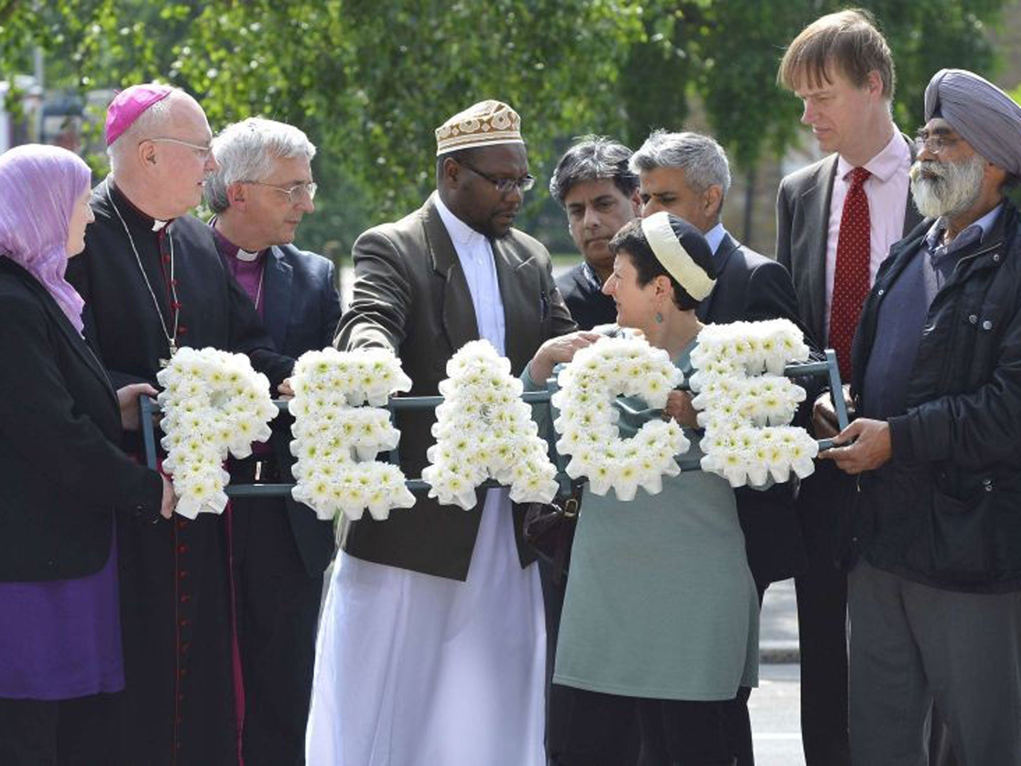 Local community representatives and faith leaders lay flowers near the scene of the killing of Lee Rigby's murder