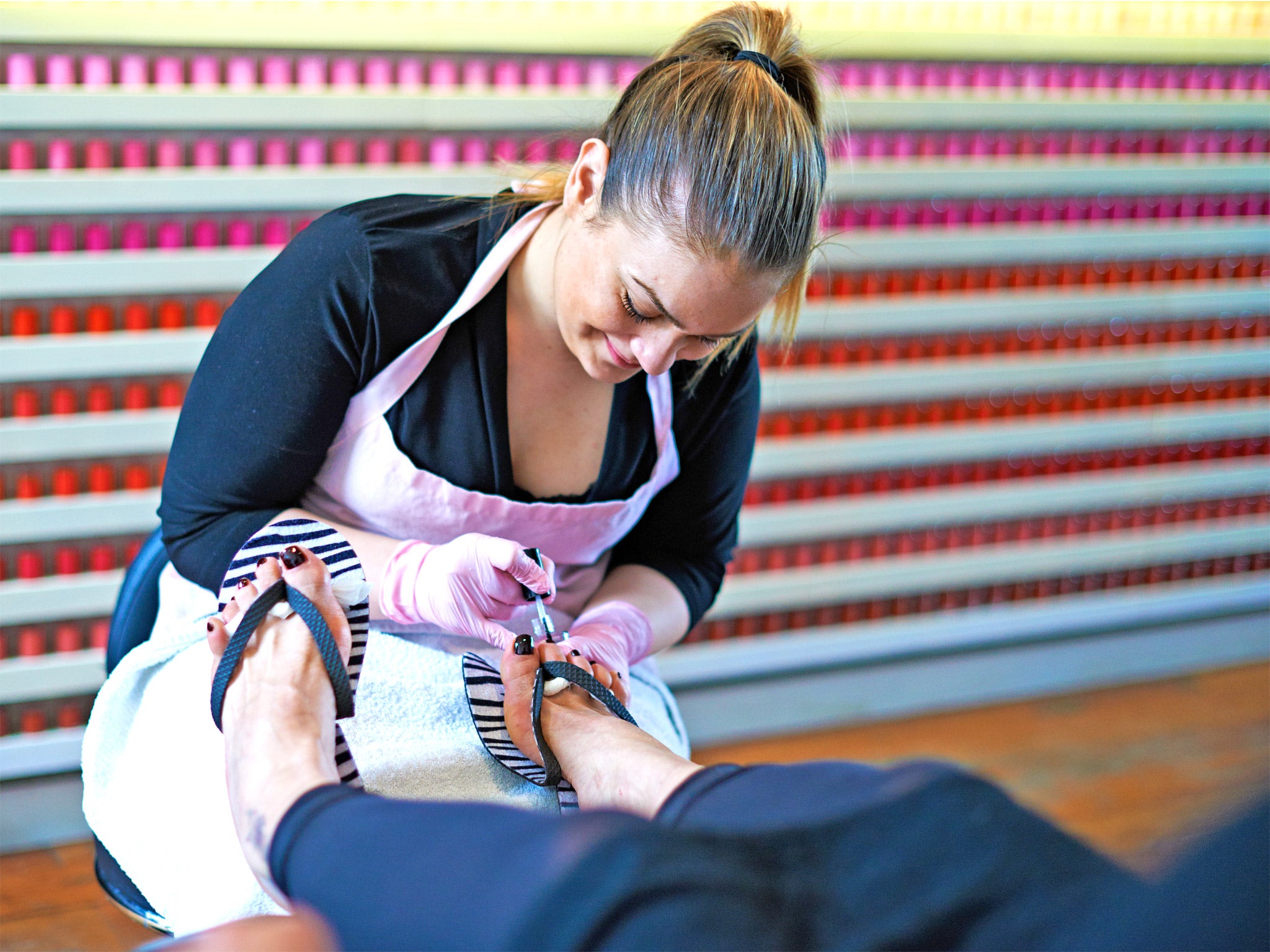 A beautician at work in Coco Nail Bar in Portobello Road, west London, which offers 222 shades of varnish