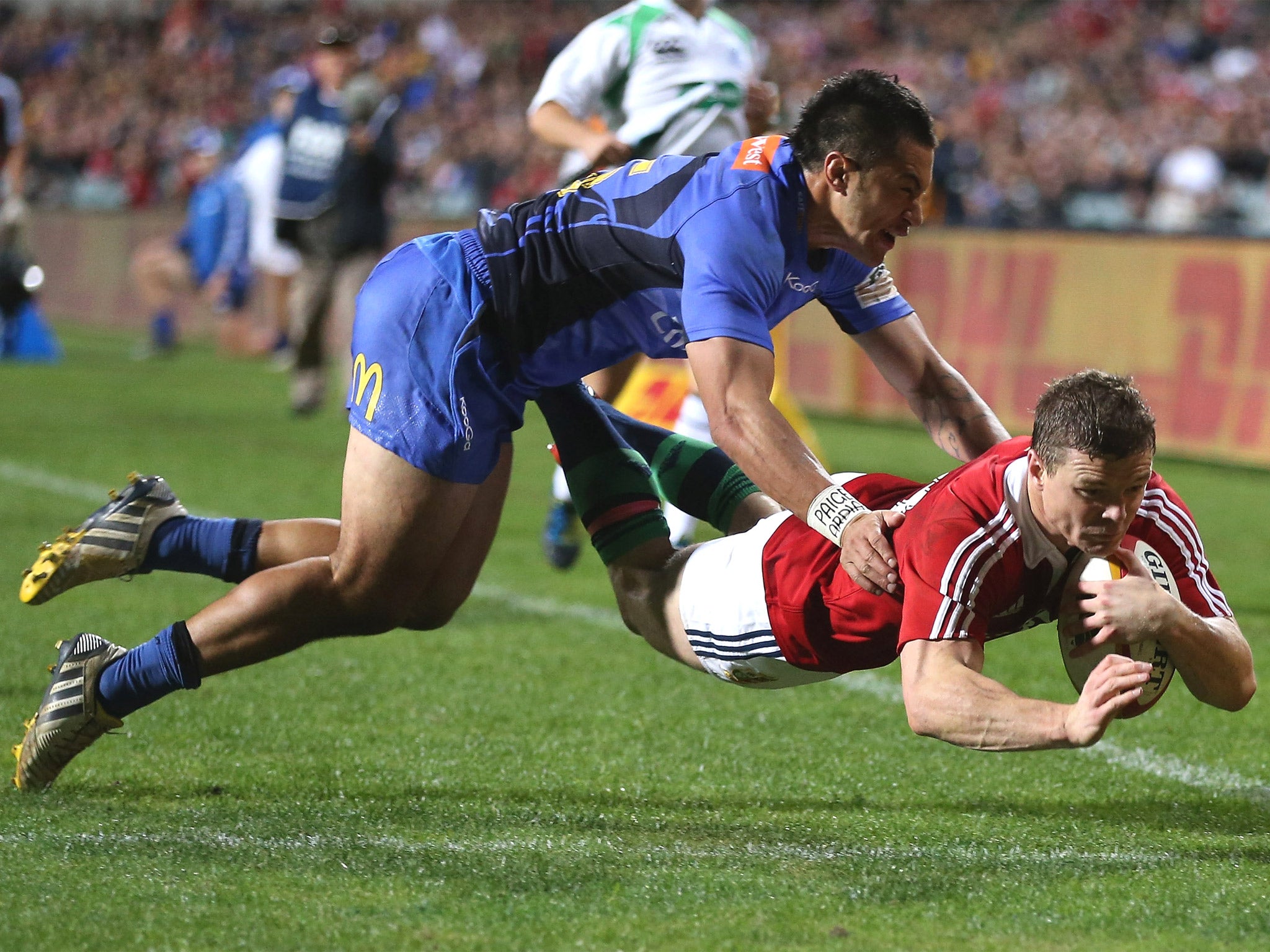 Brian O’Driscoll dives over for a Lions try despite the attention of Sam Christie