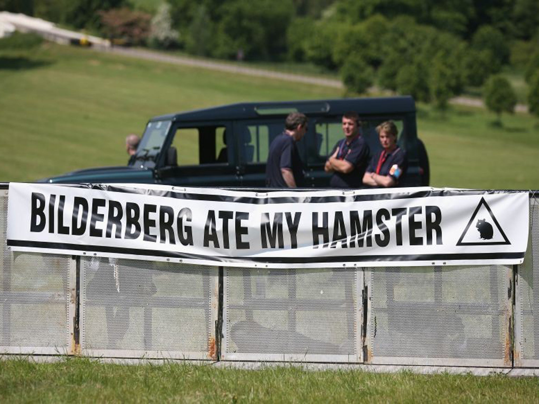 A poster adorns the security barrier of the protester encampment outside The Grove hotel, which is hosting the annual Bilderberg conference near Watford