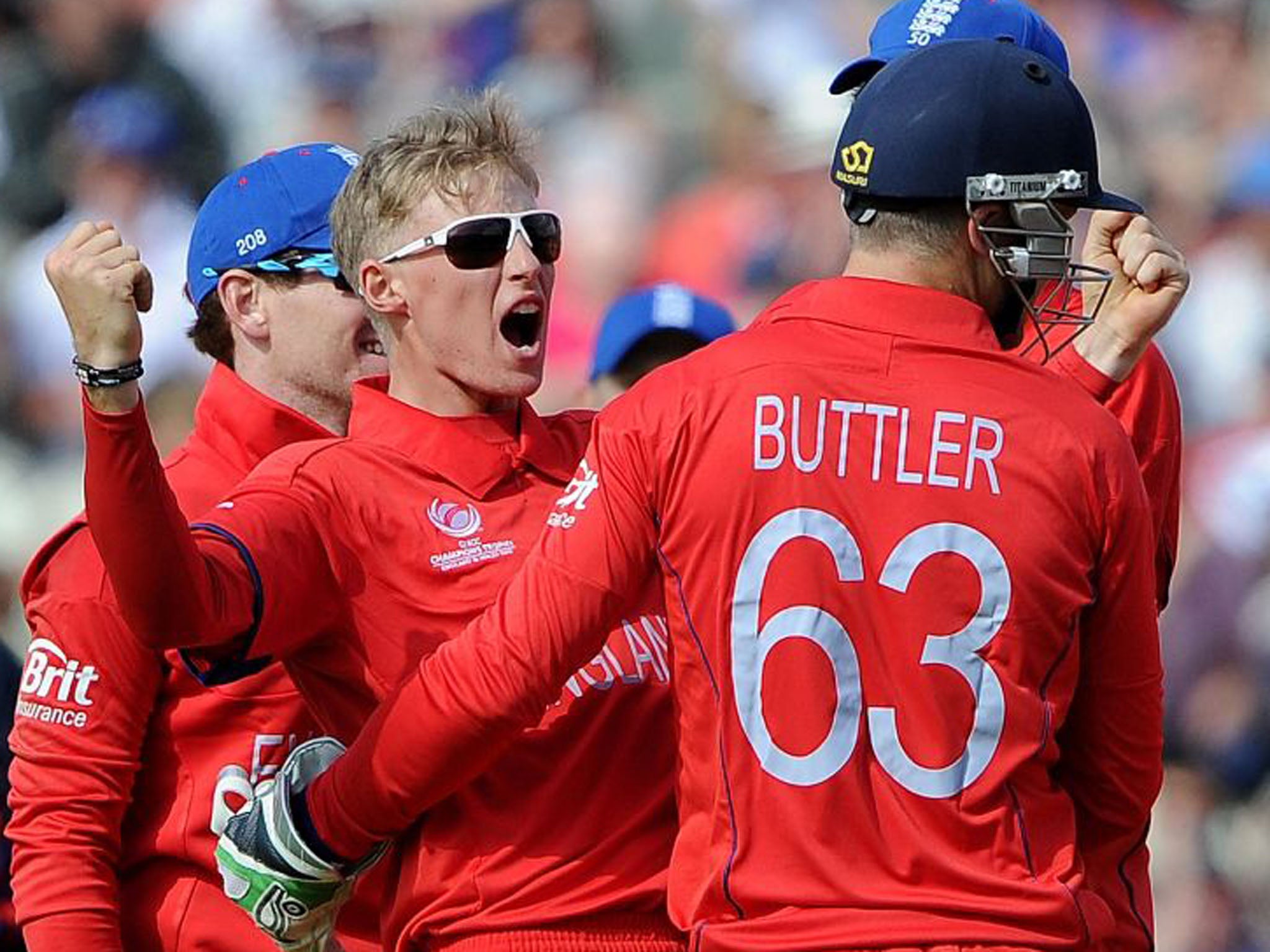 England's Joe Root, centre, celebrates after claiming the wicket of Australia's Phil Hughes.