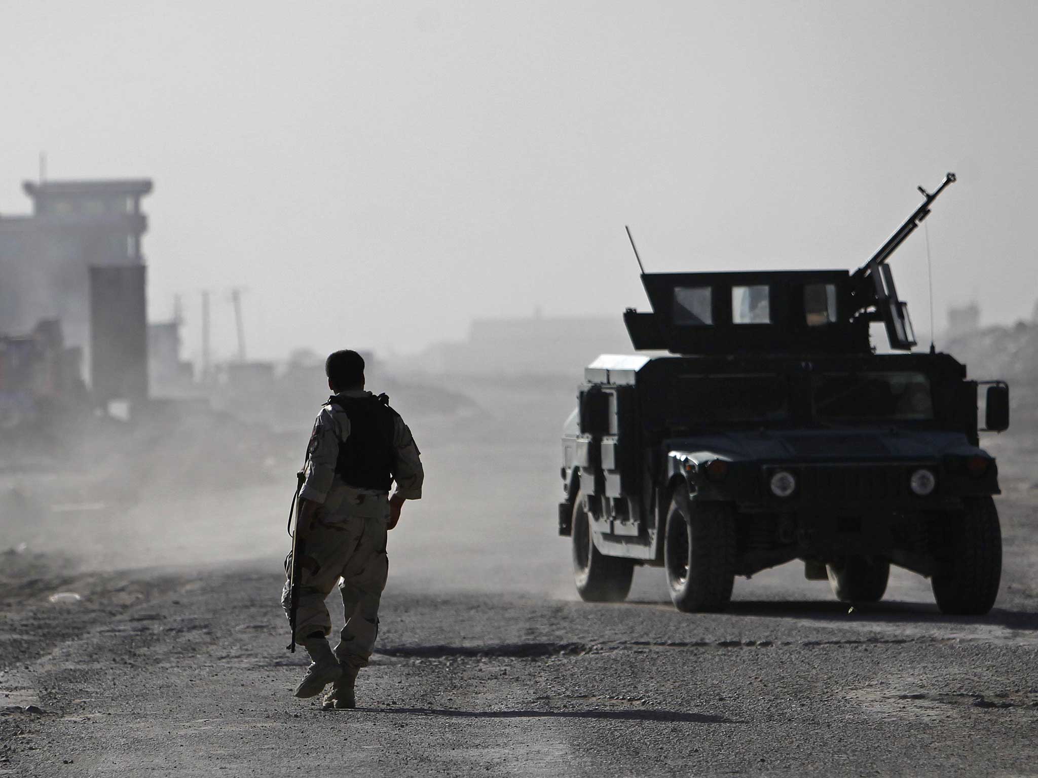 A member of the Afghan security forces walks towards the site of the attack in Kabul