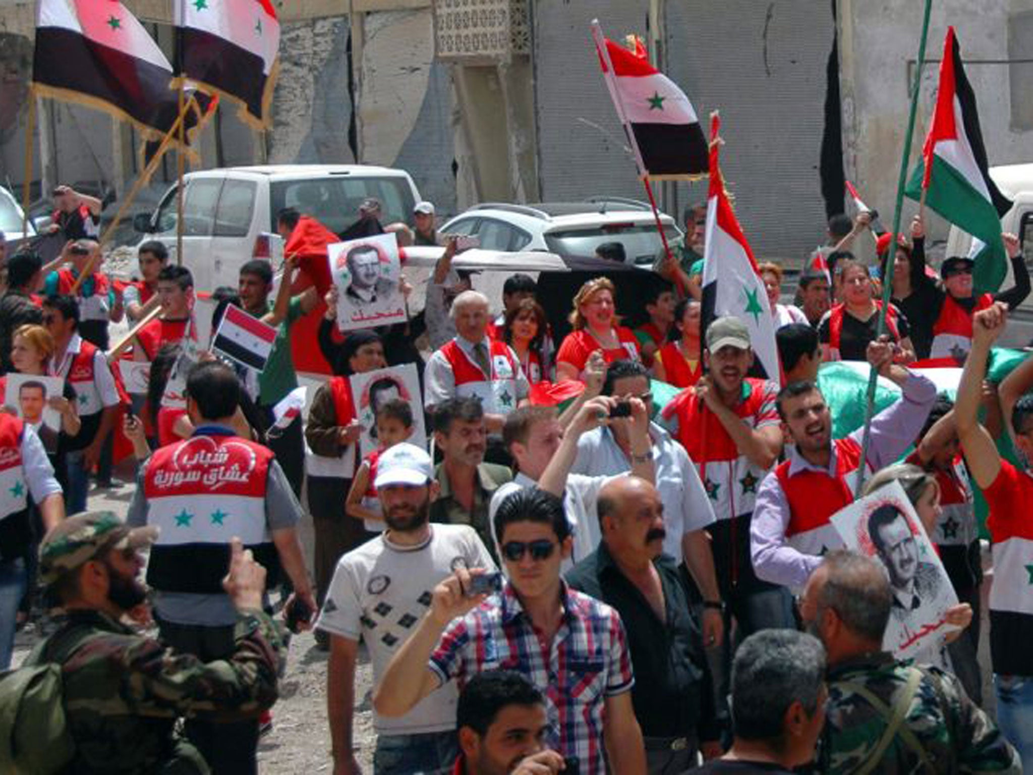 People jubilating in the center of Qusayr as they celebrate the Syrian government's recapture of the town earlier in the week after nearly three weeks of heavy fighting