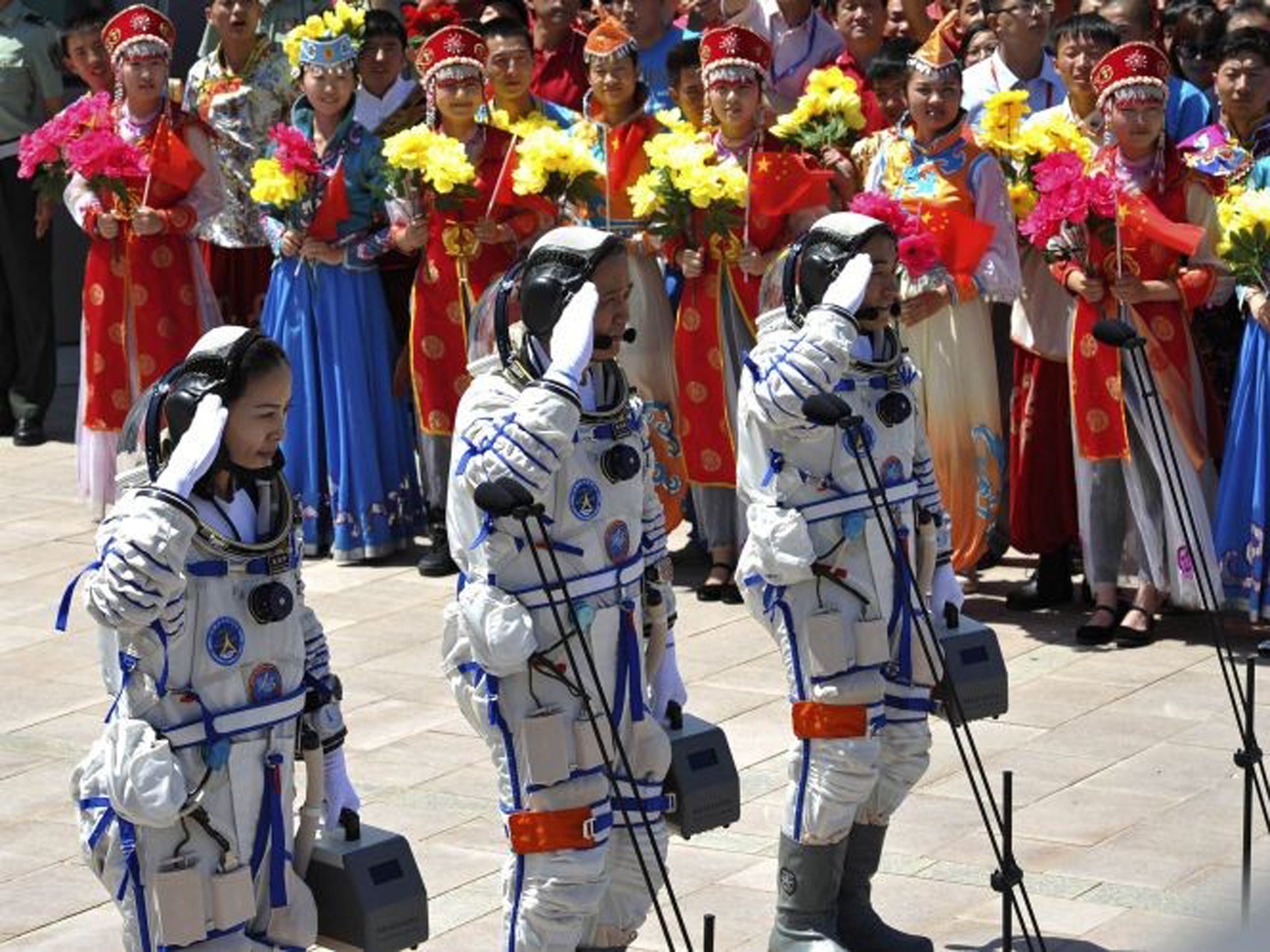 Chinese astronauts (front L-R) Wang Yaping, mission commander Nie Haisheng and Zhang Xiaoguang prepare to board the Shenzhou-10 spacecraft