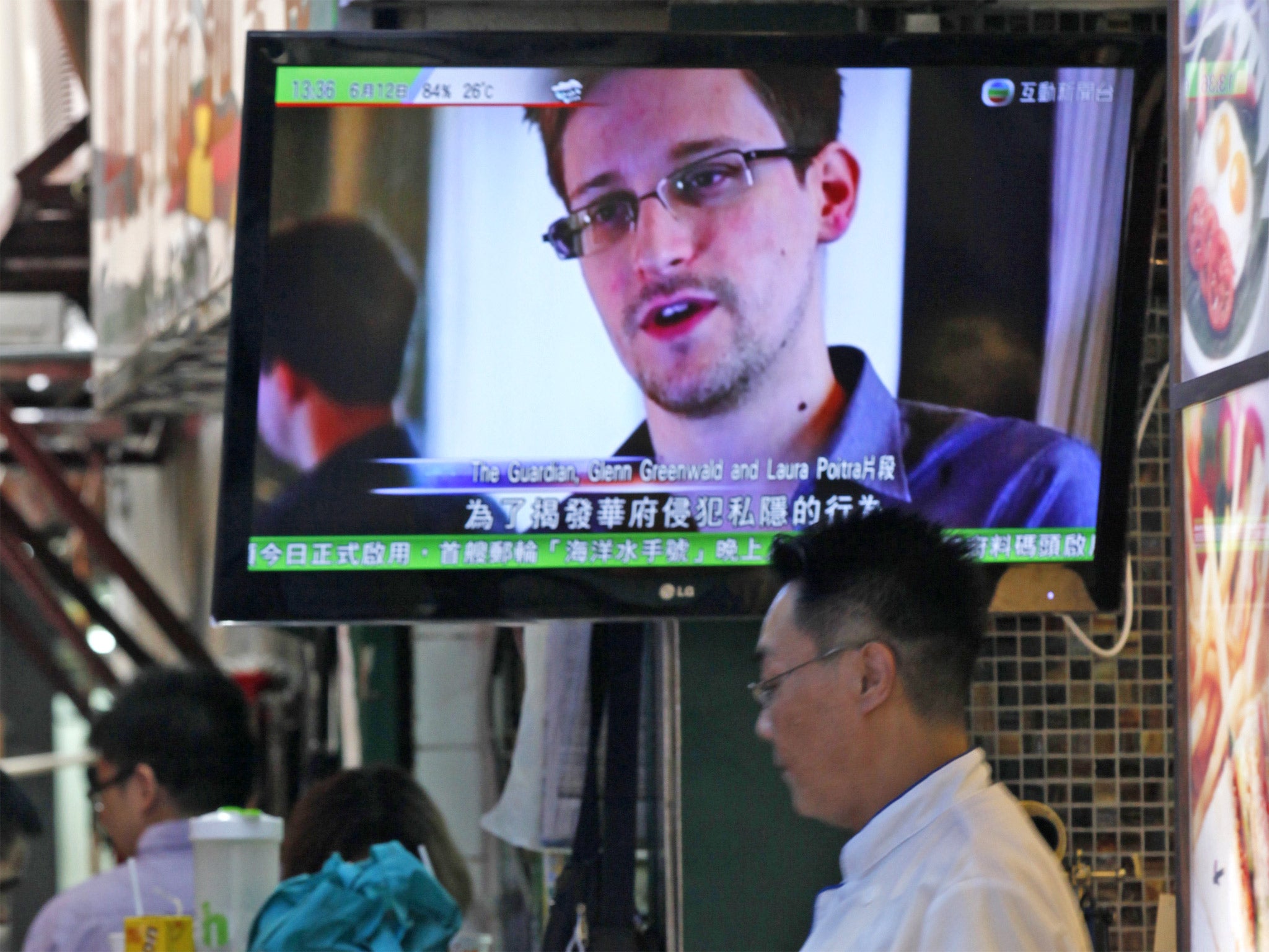 A TV screen shows Edward Snowden appearing on the news, at a restaurant in Hong Kong