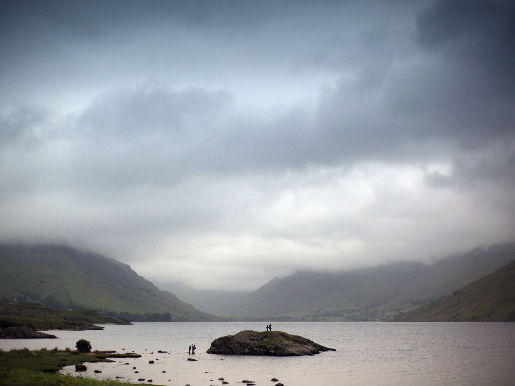 Children paddle against the backdrop of Wastwater in the Lake District