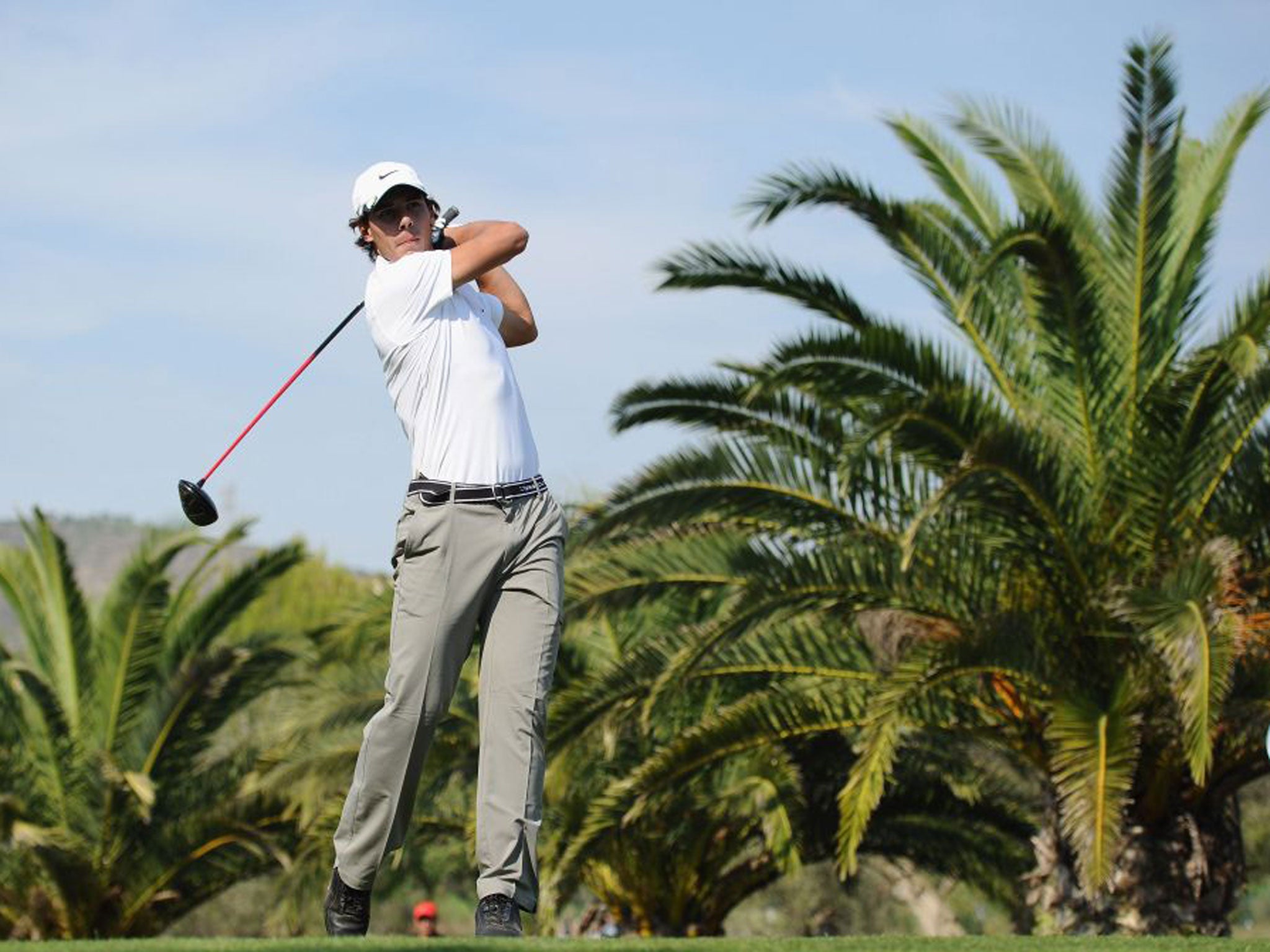 Rafael Nadal drives off the tee on a golf course in his native Majorca