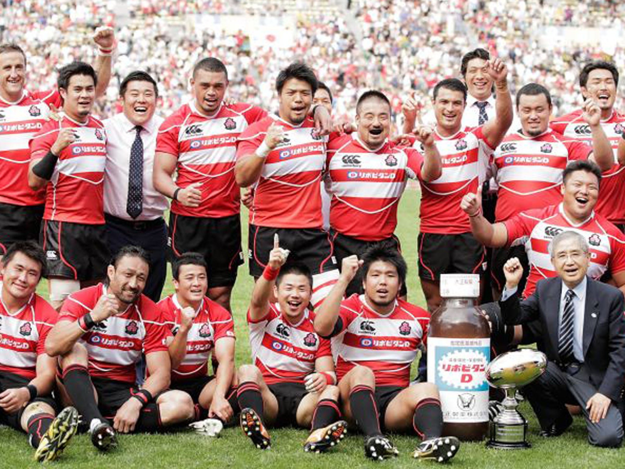 The Japan team celebrate after their historic win over Wales