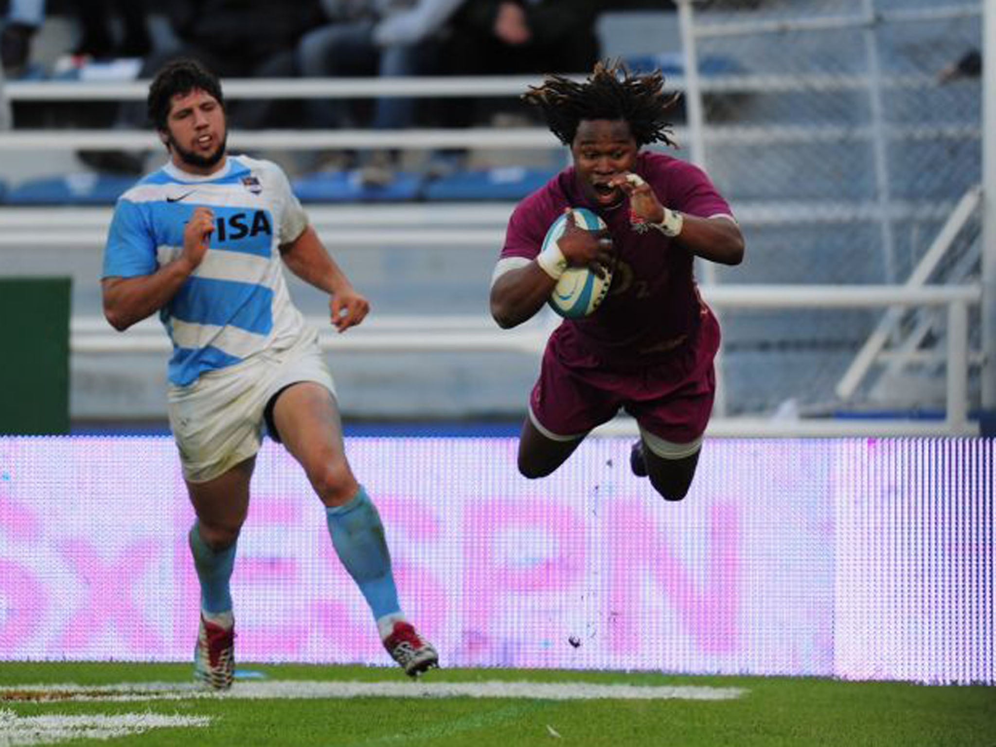 Marland Yarde, right, dives in to score for England. The wing scored two tries on his Test debut as England won 51-26