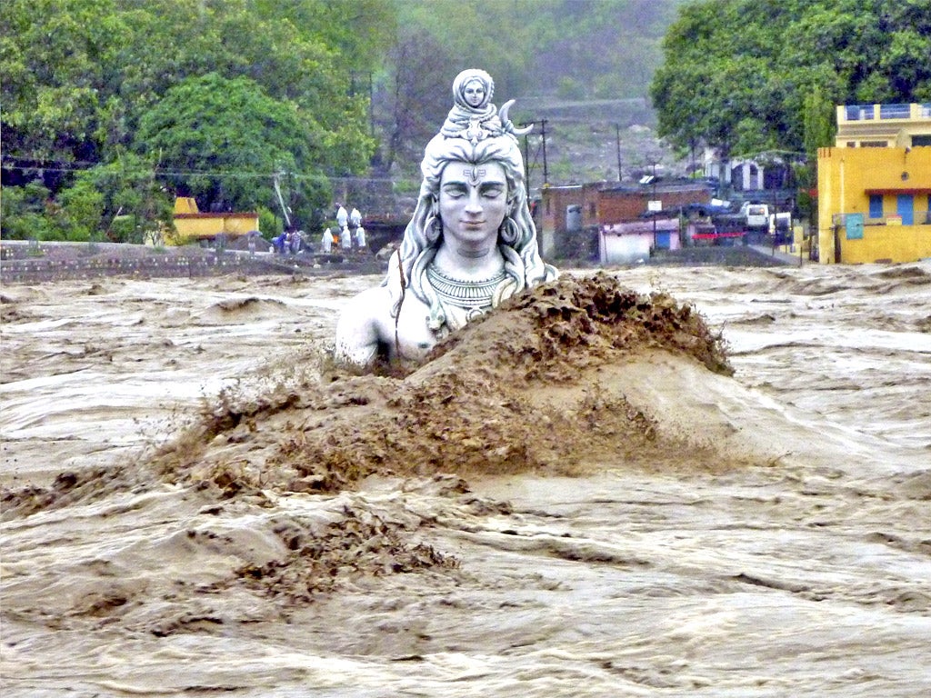 A submerged idol of Hindu Lord Shiva stands in the flooded River Ganges in Rishikesh, in the northern Indian state of Uttarakhand