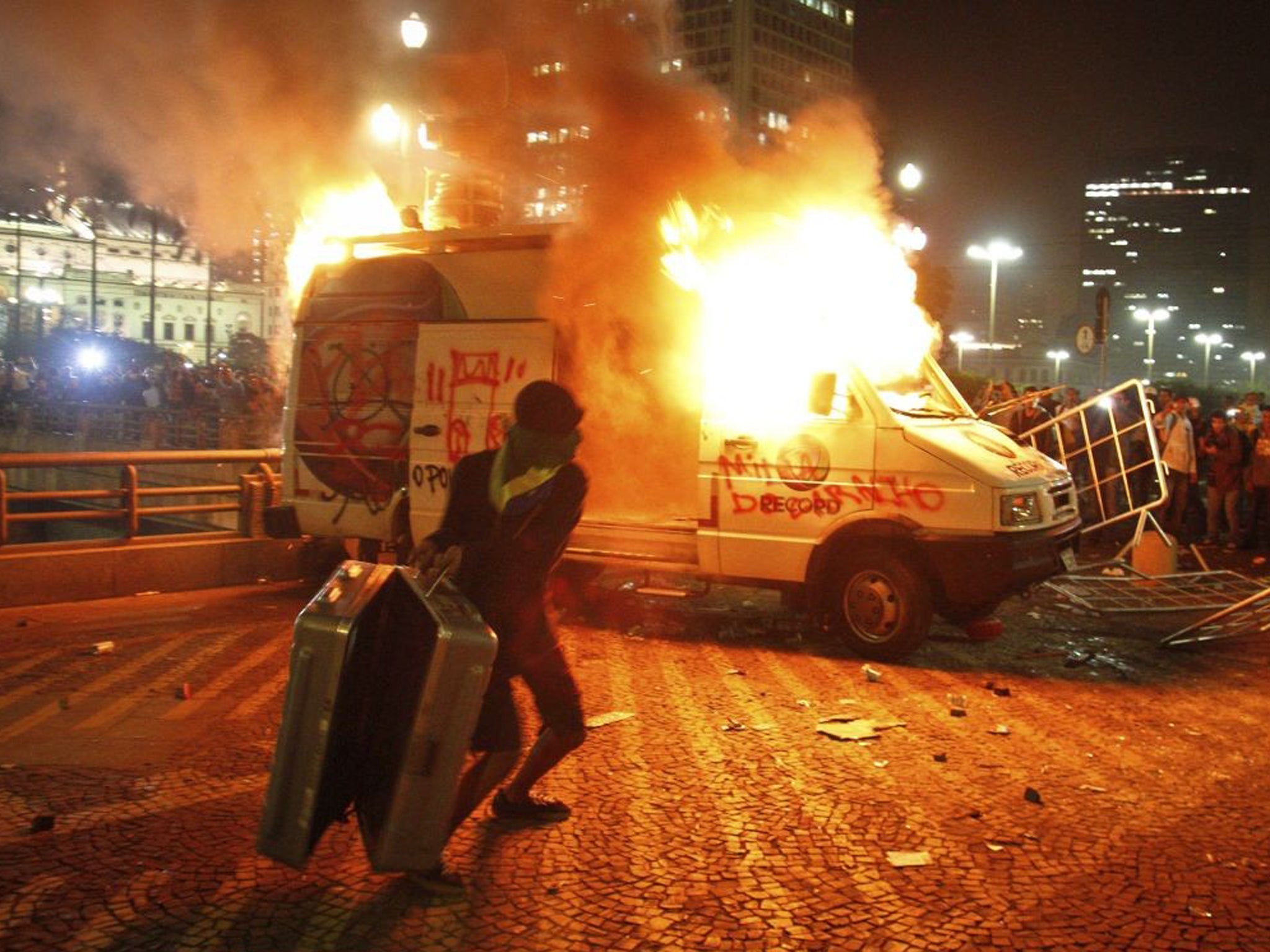 Demonstrators set fire to a car in Sao Paulo