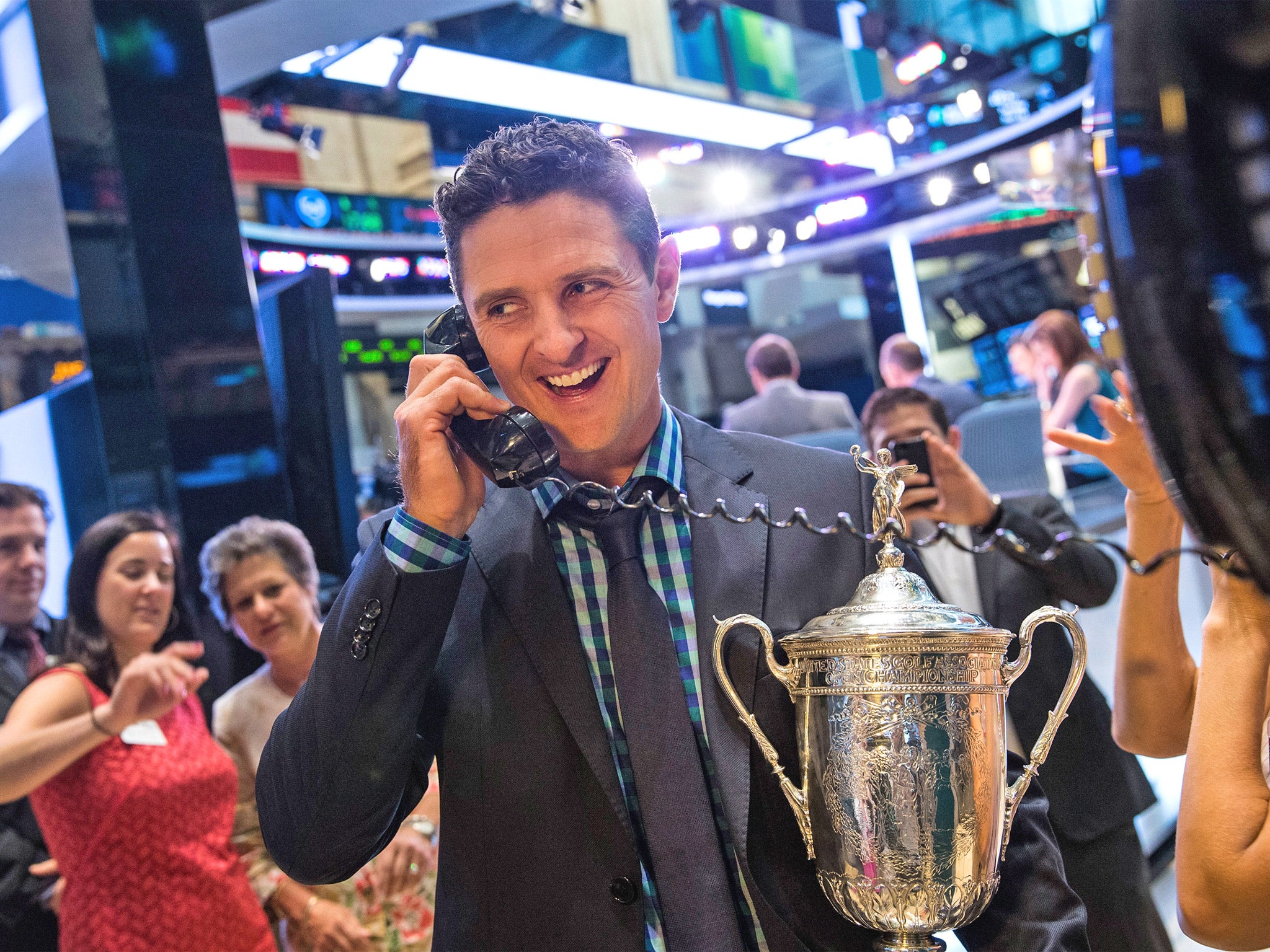 Justin Rose answers the phone during a visit to the New York Stock Exchange