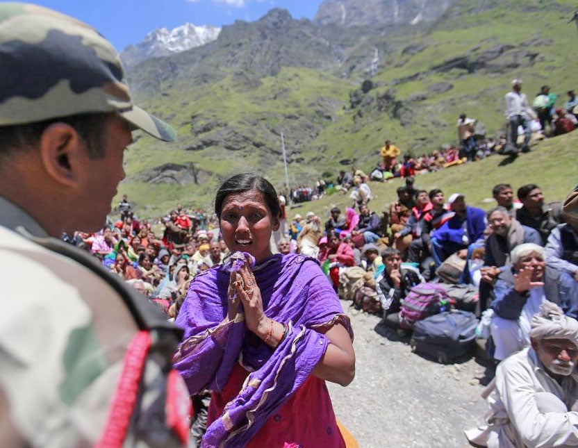 A survivor pleads with a soldier to allow her mother to board an army helicopter during rescue operations at Badrinath in the Himalayan state of Uttarakhand